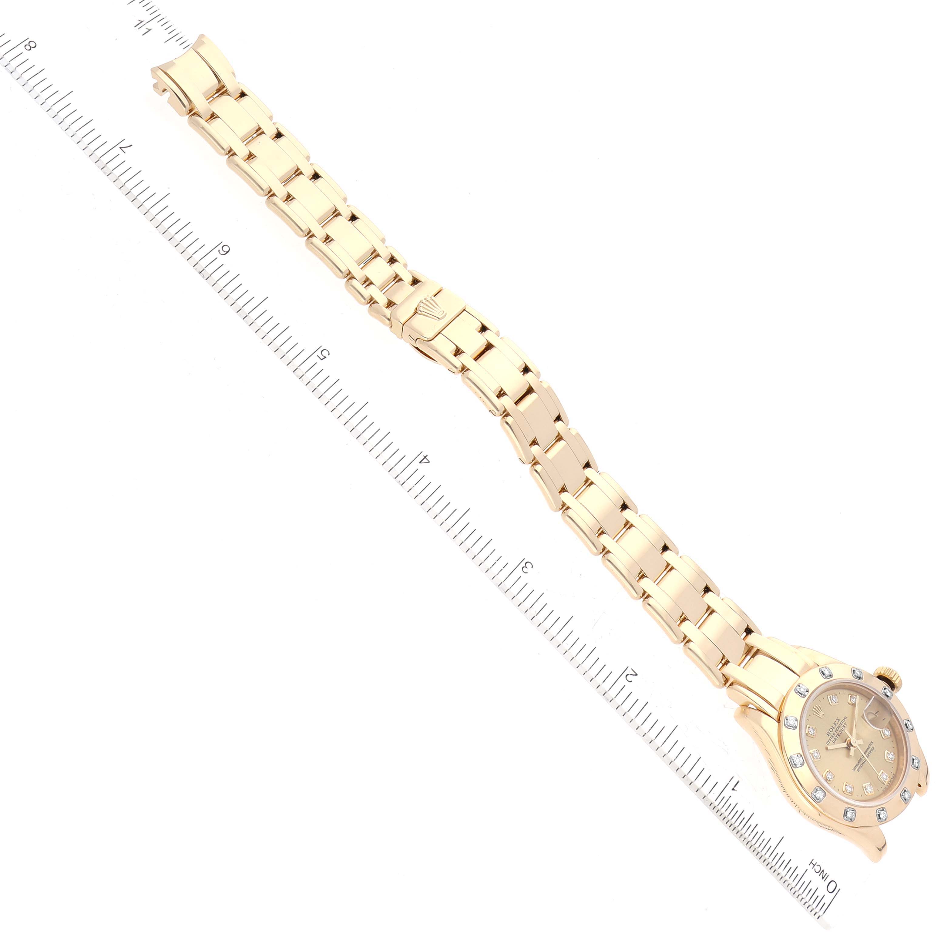 This image shows a top-down view of a Rolex Pearlmaster 80318 Women's Yellow Gold Champagne Dial 80318 Women's Yellow Gold Champagne Dial watch, highlighting its face and bracelet in full length alongside a ruler for scale.