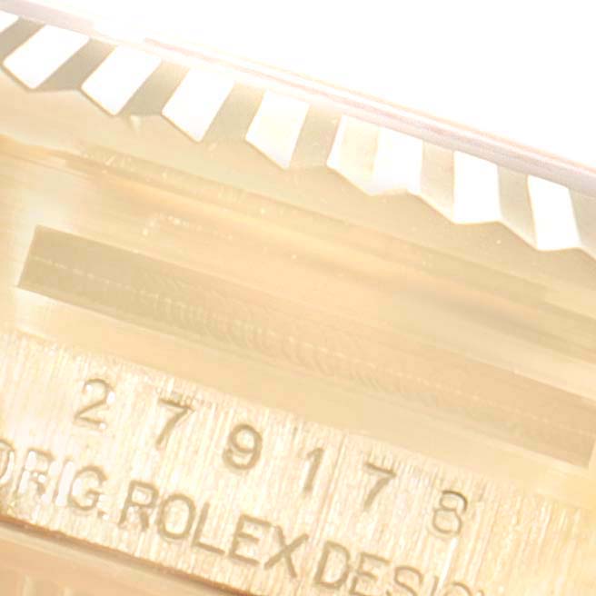 This close-up image shows the side view of the bezel and case of a Rolex President 279178 Women
s Yellow Gold Champagne Dial 279178 Women
s Yellow Gold Champagne Dial model watch, including part of its engraved serial number.