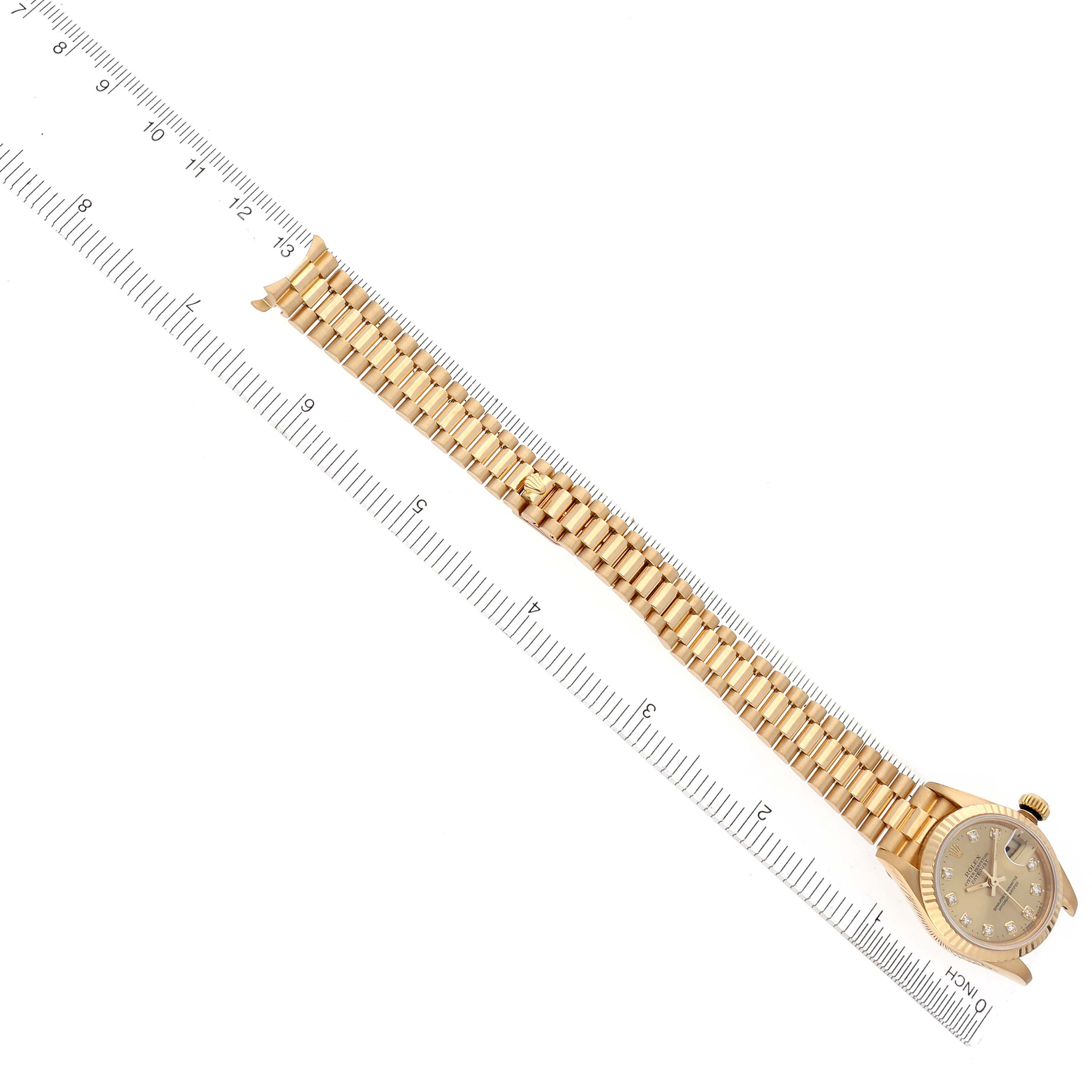 The image shows a top view of the Rolex President 69178 Women's Yellow Gold Champagne Dial 69178 Women's Yellow Gold Champagne Dial watch, highlighting the bracelet and face alongside a ruler for scale.