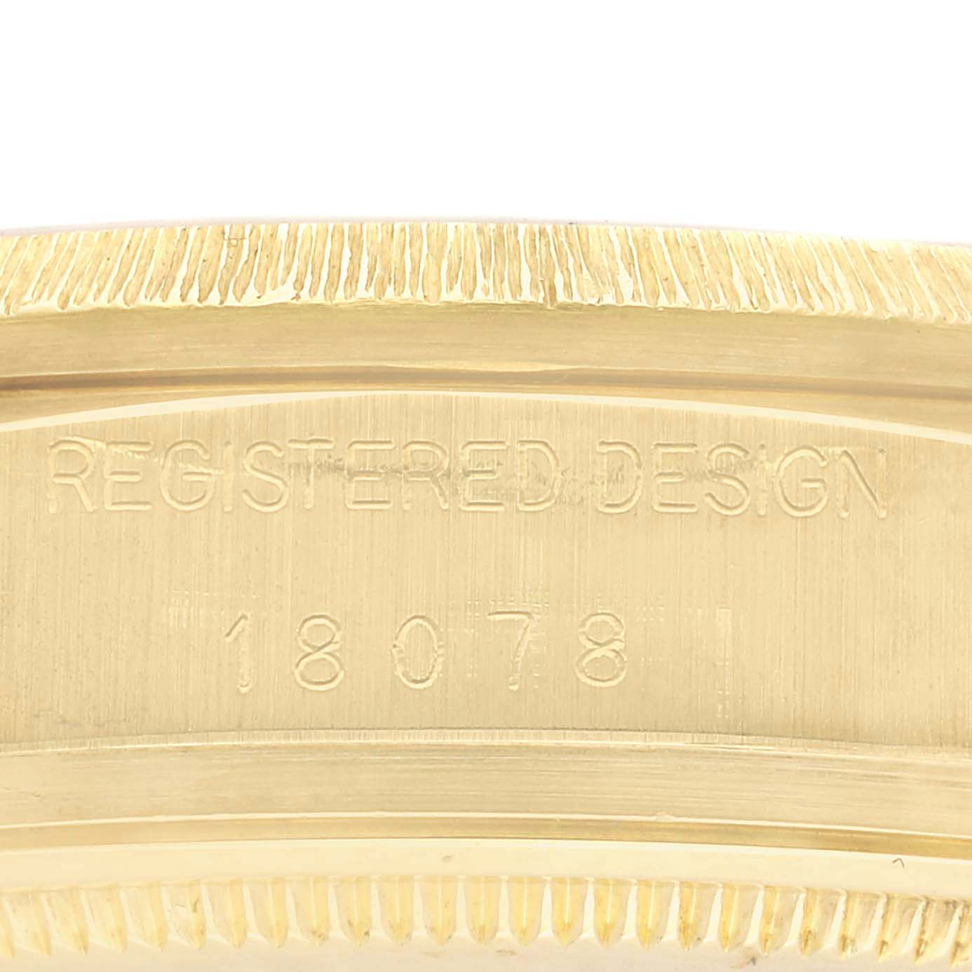 The image shows the side engraving of a Rolex President 18078 Men's Yellow Gold Champagne Dial 18078 Men's Yellow Gold Champagne Dial model watch, displaying "REGISTERED DESIGN" and the model number "18078."