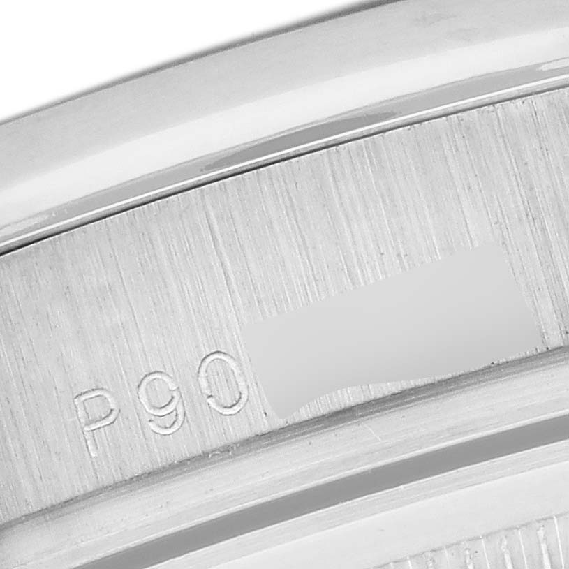 The image shows a close-up of the case back edge of a Rolex President 118296 Men
s Platinum Blue Dial 118296 Men
s Platinum Blue Dial model watch with part of the engraved serial number.