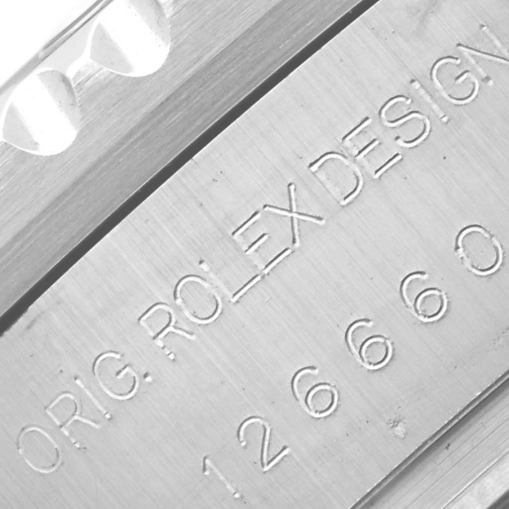 The image shows a close-up of the side of a Rolex Sea-Dweller 126660 Men's Stainless Steel Blue Dial 126660 Men's Stainless Steel Blue Dial watch case with engravings of the model number and "ORIG ROLEX DESIGN."