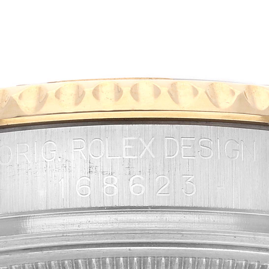 The image shows a close-up of the side of the bezel and the case of the Rolex Yacht-Master 168623 Men
s Steel and Gold (two tone) Grey Dial 168623 Men
s Steel and Gold (two tone) Grey Dial watch with engraved text and model number.