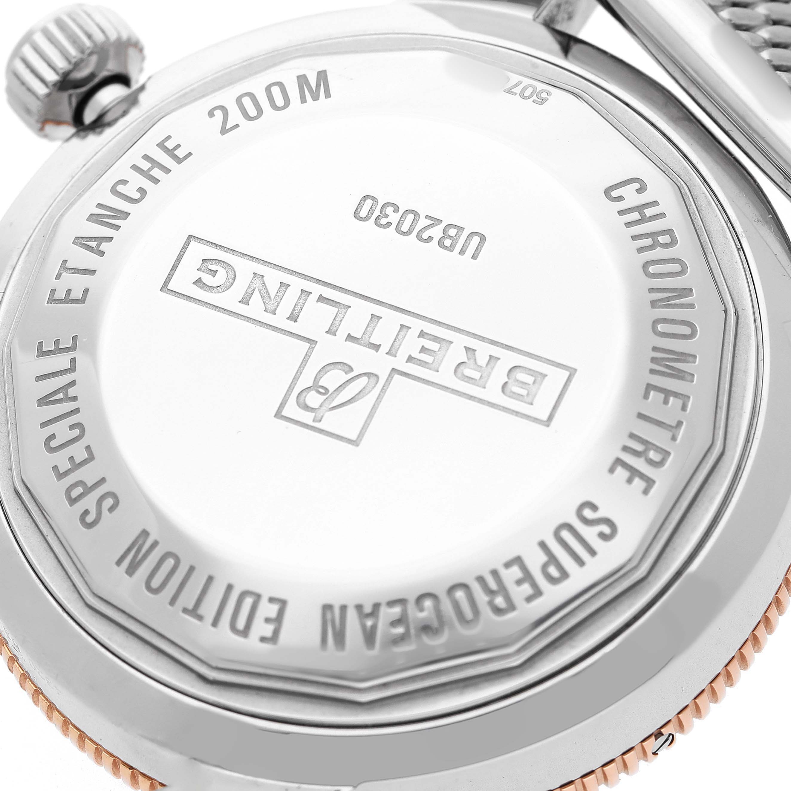 The image shows the case back of the Breitling Superocean UB2030 Men's Stainless Steel Black Dial watch at an angle highlighting the engraving and the crown.