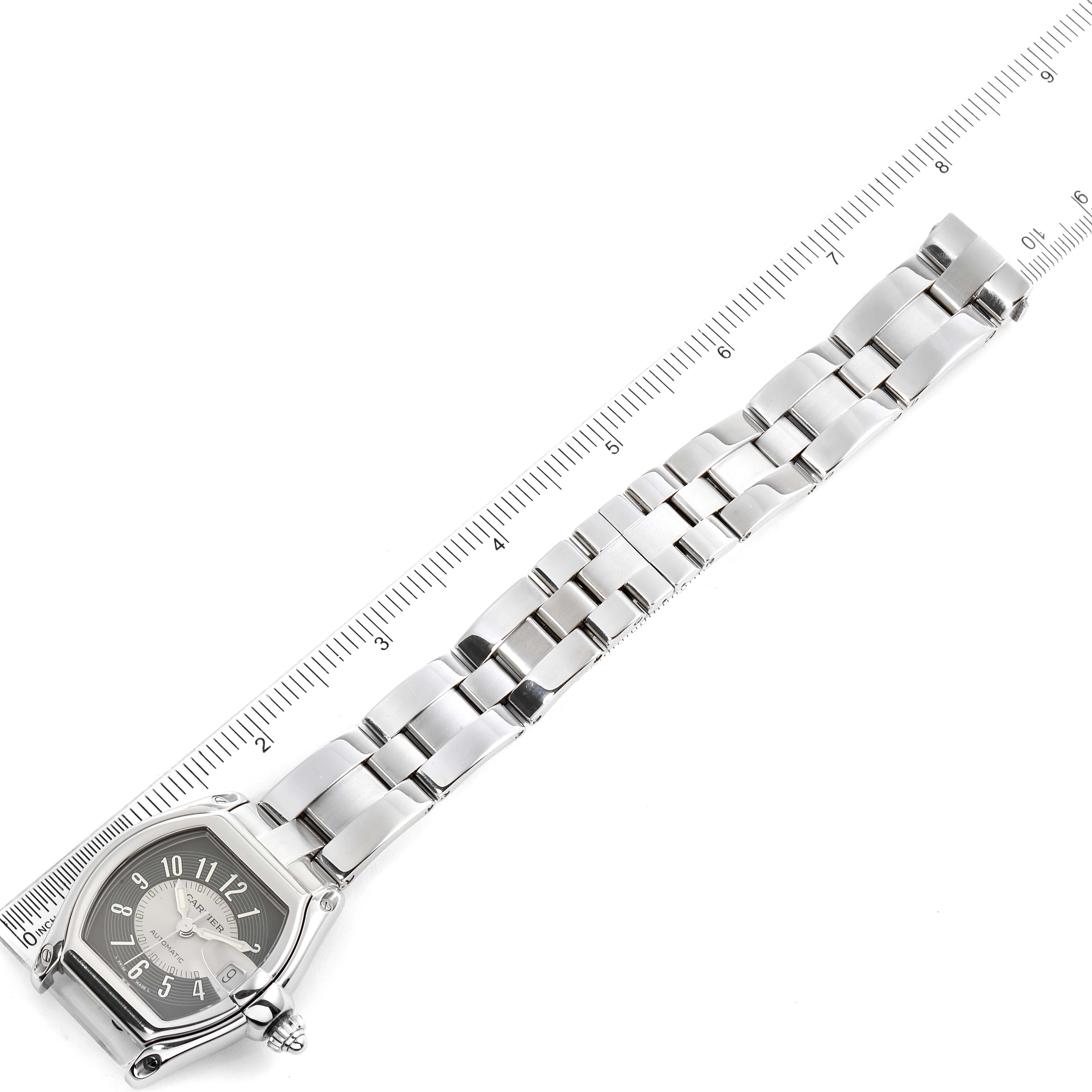 The image shows the Cartier Roadster W62001V3 Men's Stainless Steel Grey Dial W62001V3 Men's Stainless Steel Grey Dial watch at an angle, highlighting its face and metal strap alongside a ruler for scale.