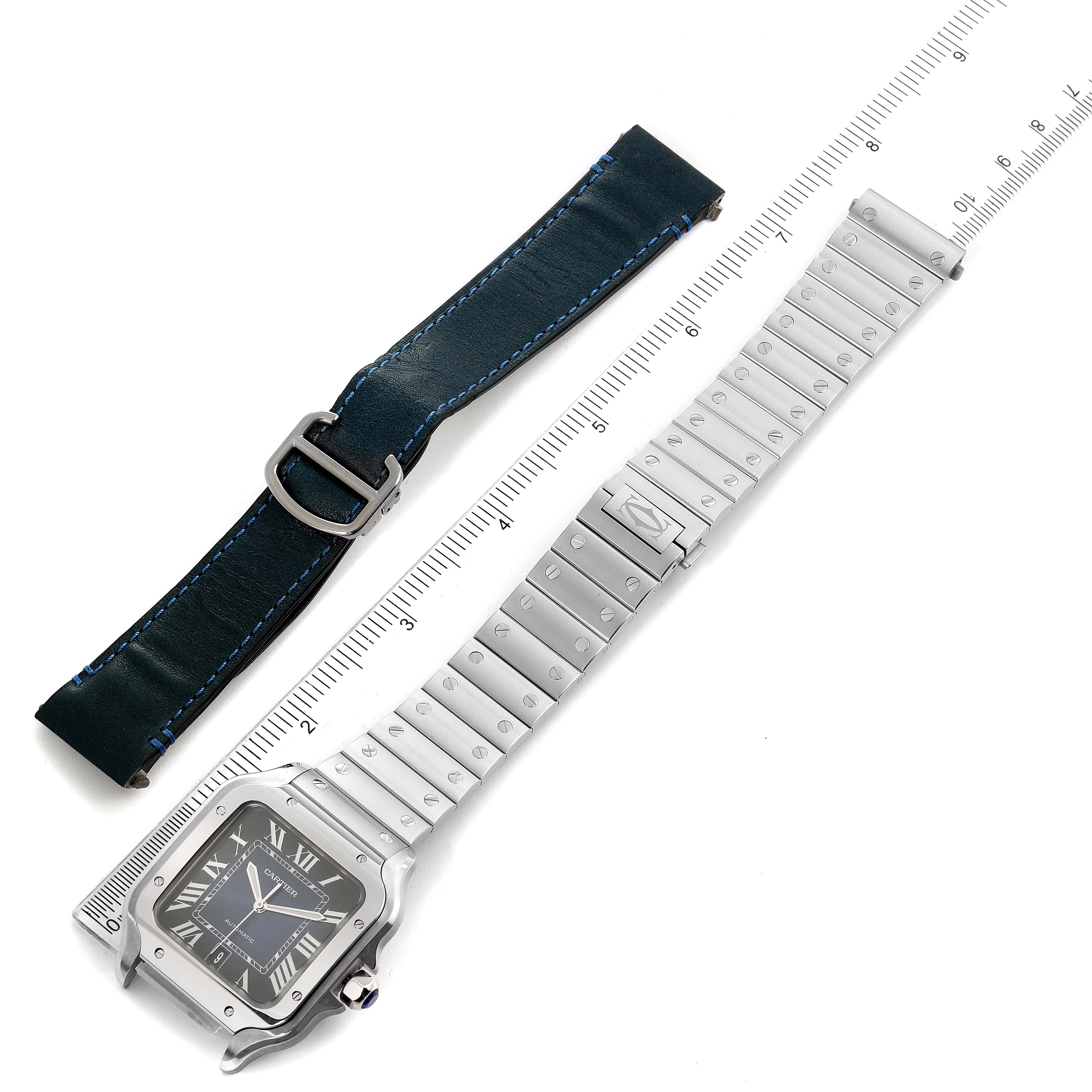 This image shows a Cartier Santos WSSA0013 Men's Stainless Steel Blue Dial WSSA0013 Men's Stainless Steel Blue Dial watch with a metal bracelet and an additional leather strap, viewed from above.