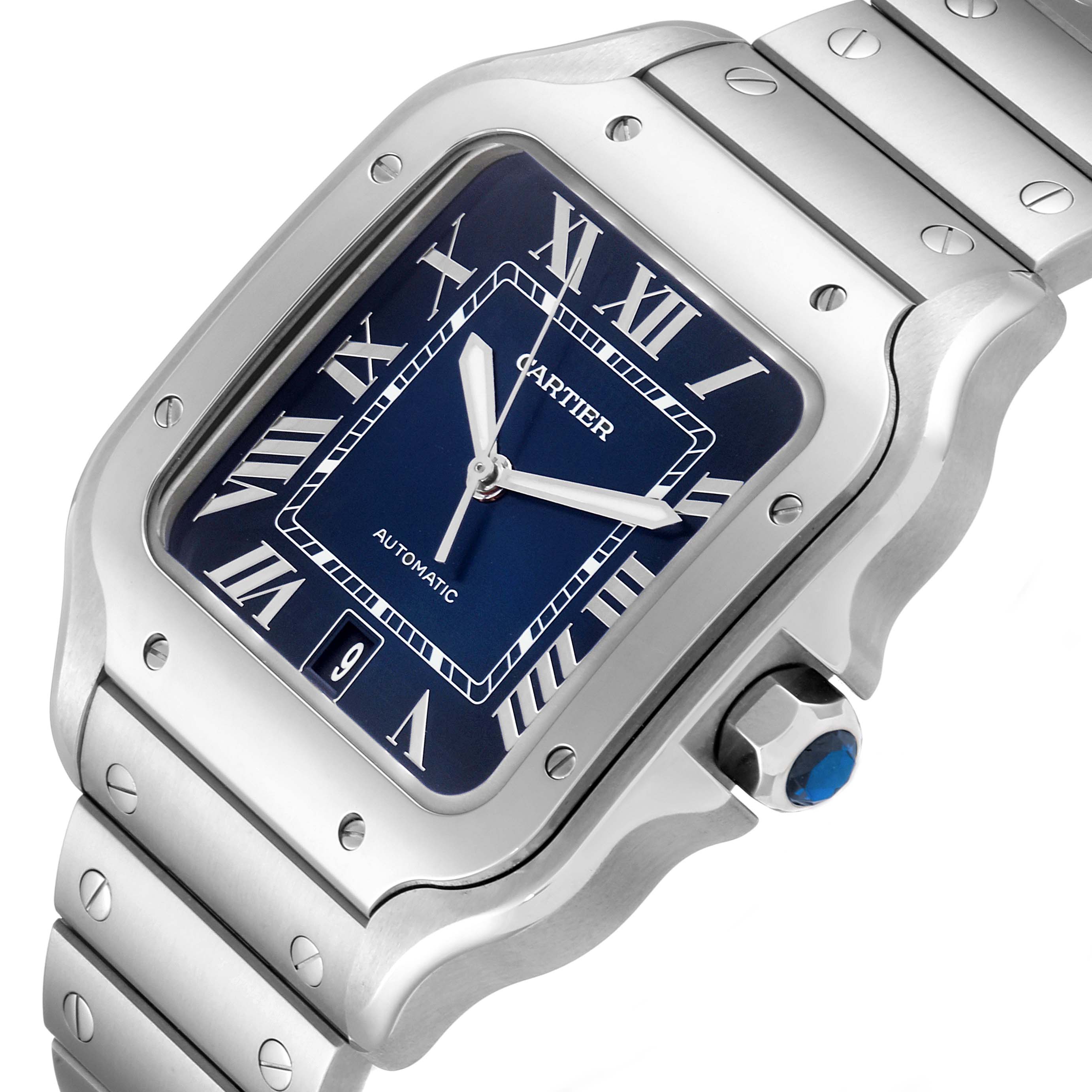 The image shows a close-up of the Cartier Santos WSSA0013 Men's Stainless Steel Blue Dial WSSA0013 Men's Stainless Steel Blue Dial watch face and part of the band, highlighting its design and blue dial.