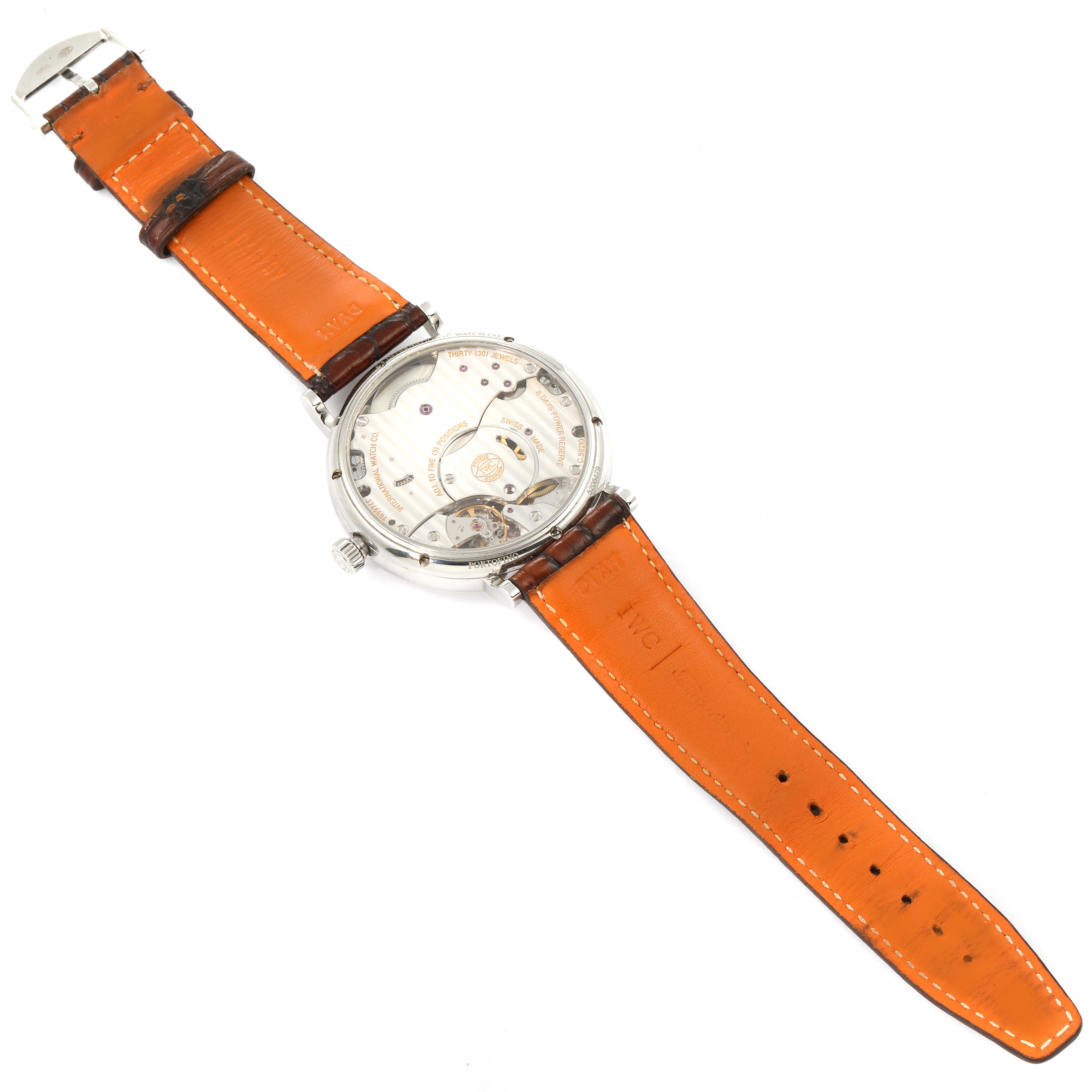 The IWC Portofino IW510103 Men's Stainless Steel Silver Dial IW510103 Men's Stainless Steel Silver Dial watch is shown from the back, displaying the inner mechanics and an orange leather strap.