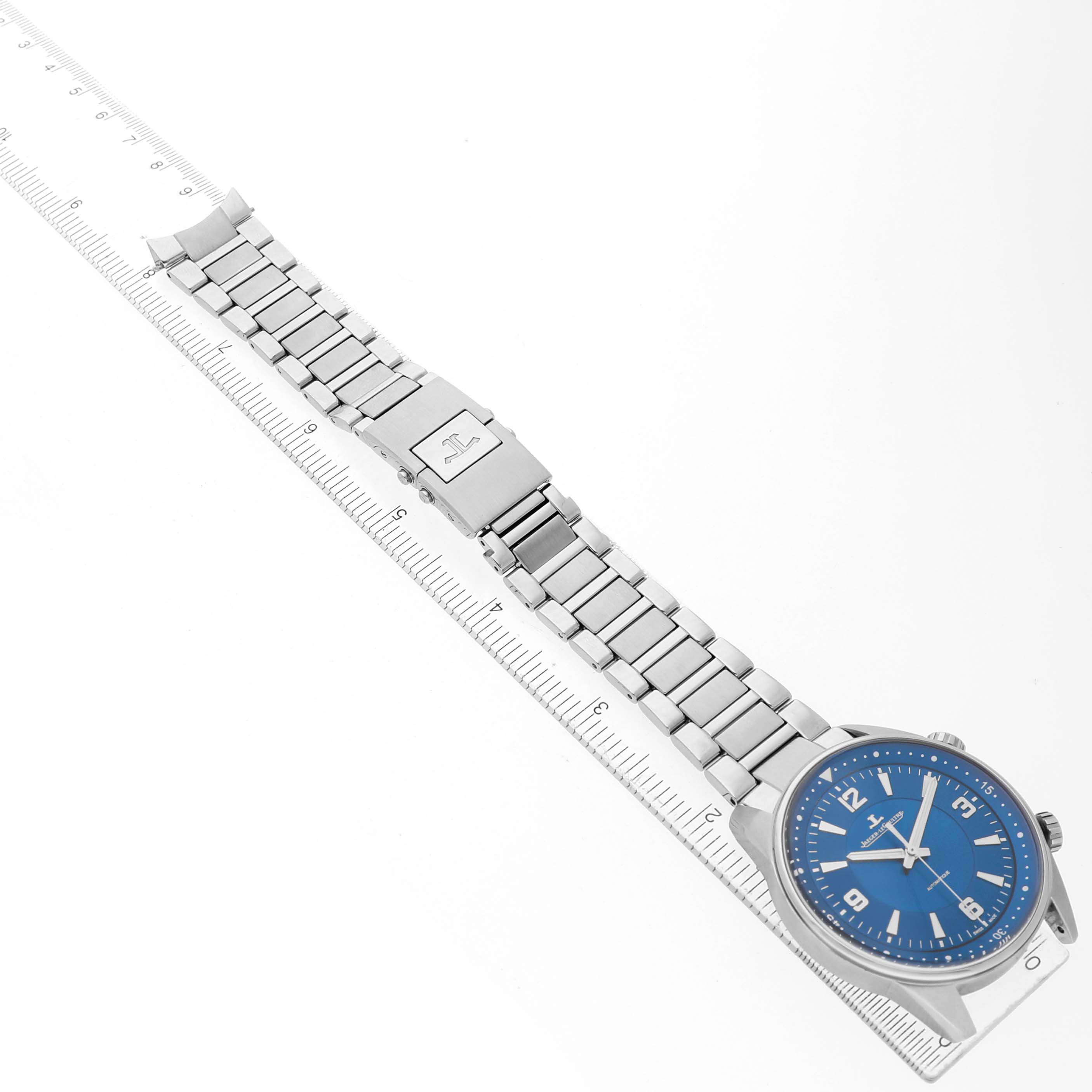 The Jaeger LeCoultre Polaris Q9008180 Men's Stainless Steel Blue Dial watch is shown from an angled top-down view, displaying the blue dial, stainless steel case, and bracelet.