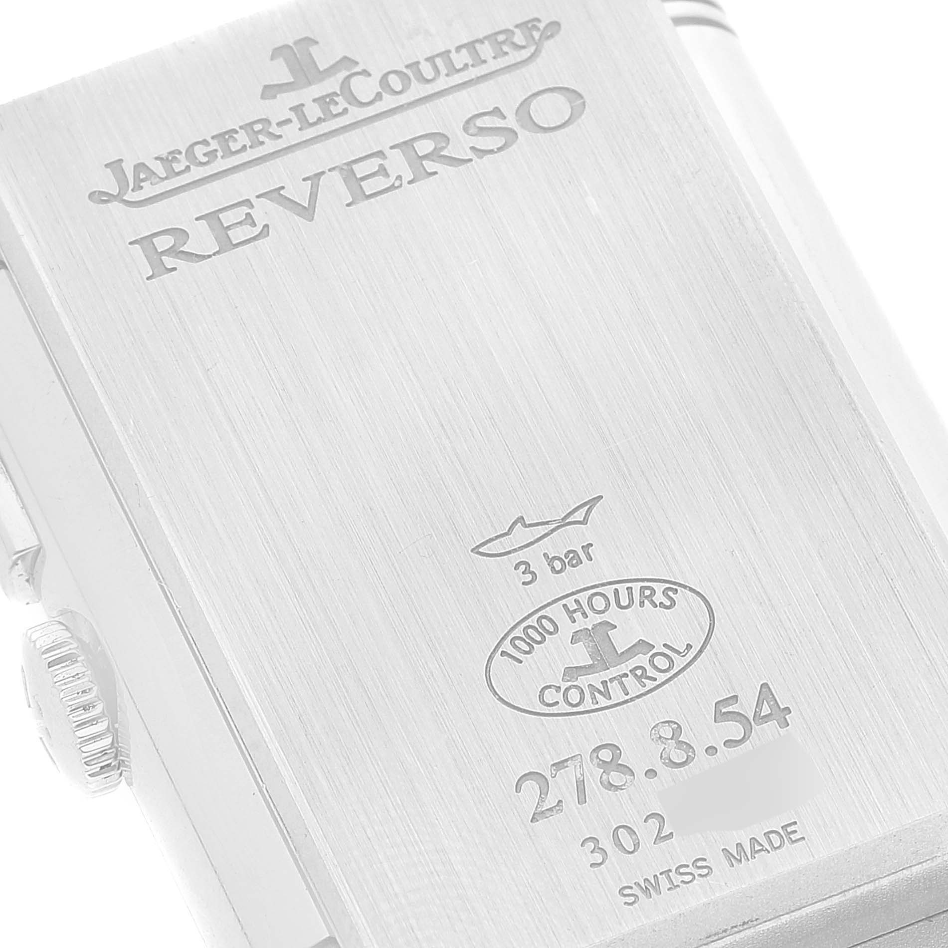 The image shows the back case of a Jaeger-LeCoultre Reverso watch with engraved details.