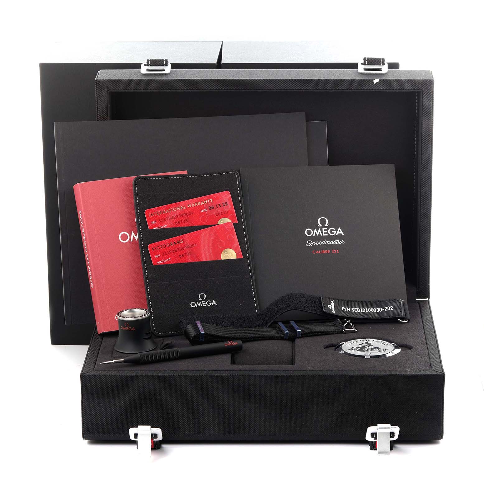 The image shows an Omega Speedmaster 311.93.42.30.99.001 Men's Platinum Black Dial 311.93.42.30.99.001 Men's Platinum Black Dial watch set, including documents, a loupe, and tools, all displayed inside a presentation box.