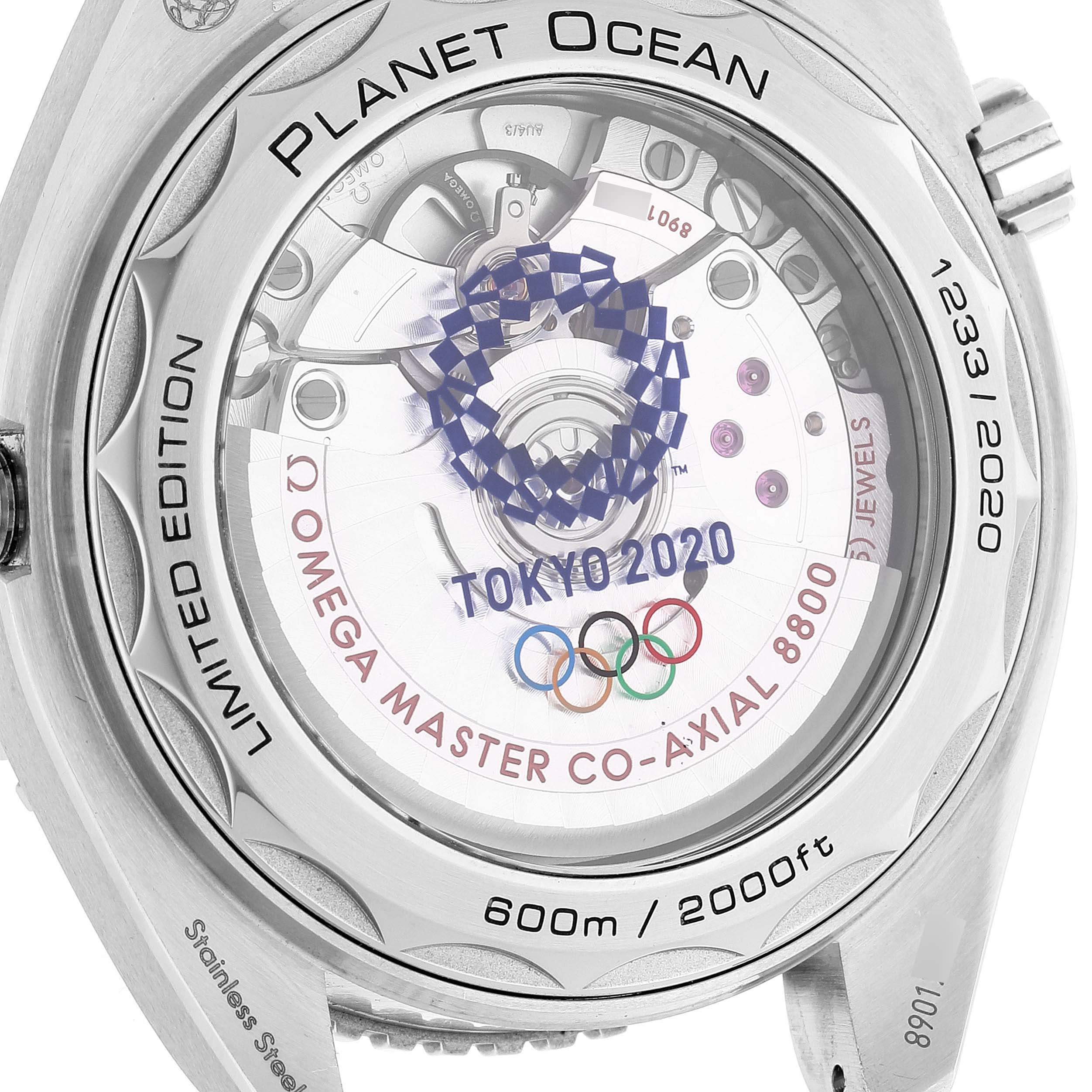 This image shows the back of the Omega Planet Ocean 522.33.40.20.04.001 Men's Stainless Steel White Dial 522.33.40.20.04.001 Men's Stainless Steel White Dial watch, displaying the movement and inscriptions like "TOKYO 2020" and "Omega Master Co-Axial 8800."