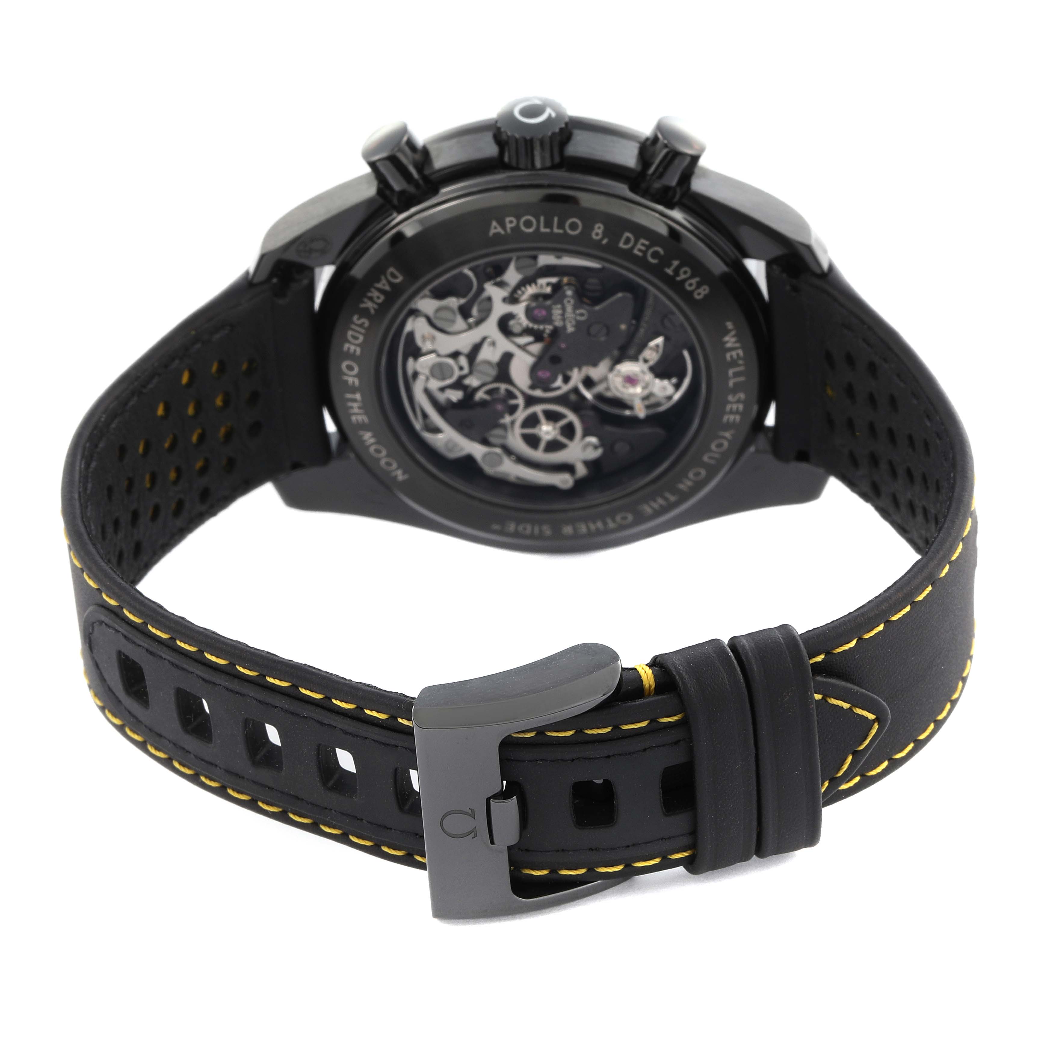 The image shows the back of an Omega Speedmaster 311.92.44.30.01.001 Men's Ceramic Black Dial 311.92.44.30.01.001 Men's Ceramic Black Dial, highlighting the movement and leather strap with yellow stitching.