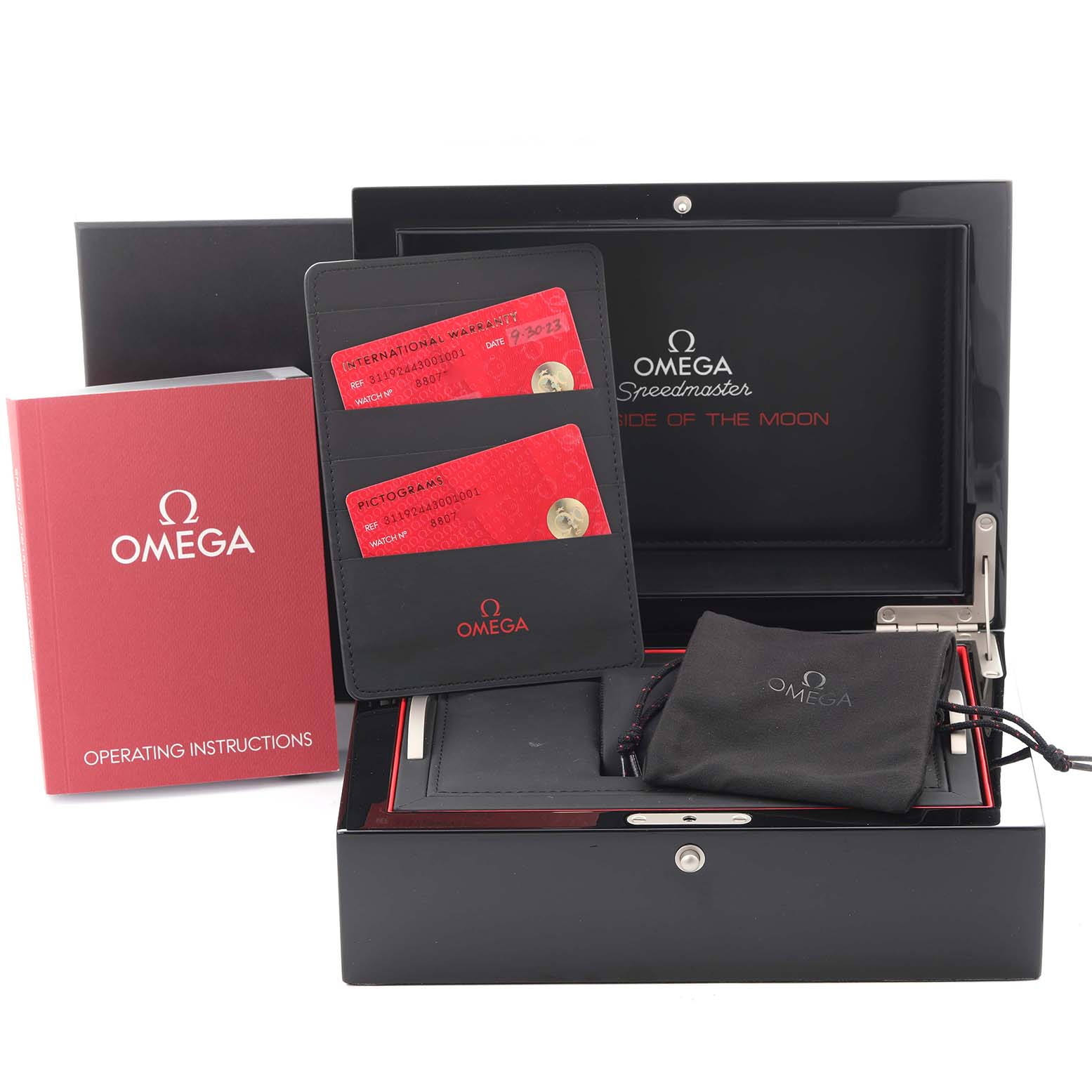 The image shows an Omega Speedmaster 311.92.44.30.01.001 Men's Ceramic Black Dial 311.92.44.30.01.001 Men's Ceramic Black Dial watch box with a booklet, cards in a holder, and a pouch from a front angle.
