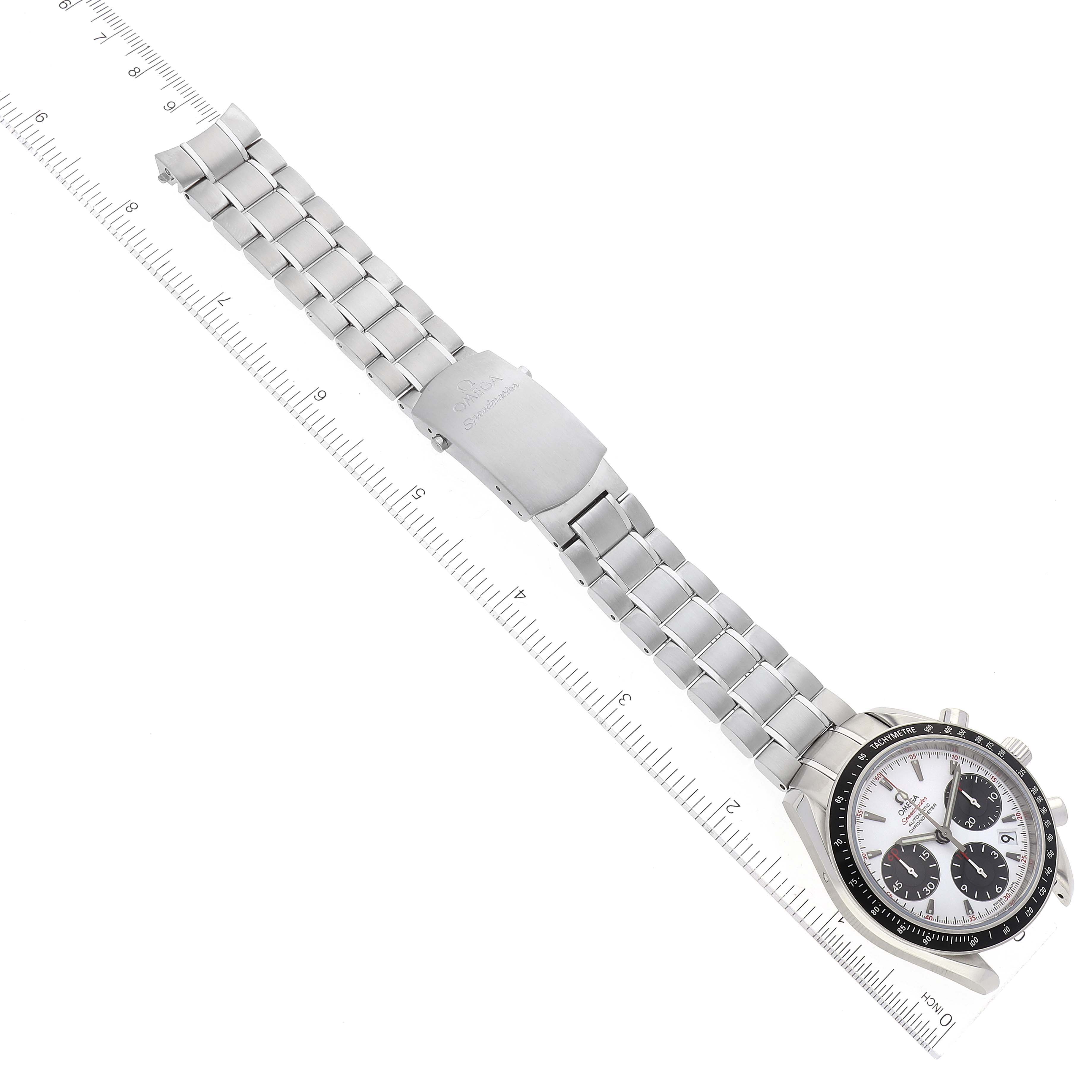 The Omega Speedmaster 323.30.40.40.04.001 Men's Stainless Steel White Dial 323.30.40.40.04.001 Men's Stainless Steel White Dial watch is shown flat with its stainless steel bracelet fully extended next to a measuring ruler.