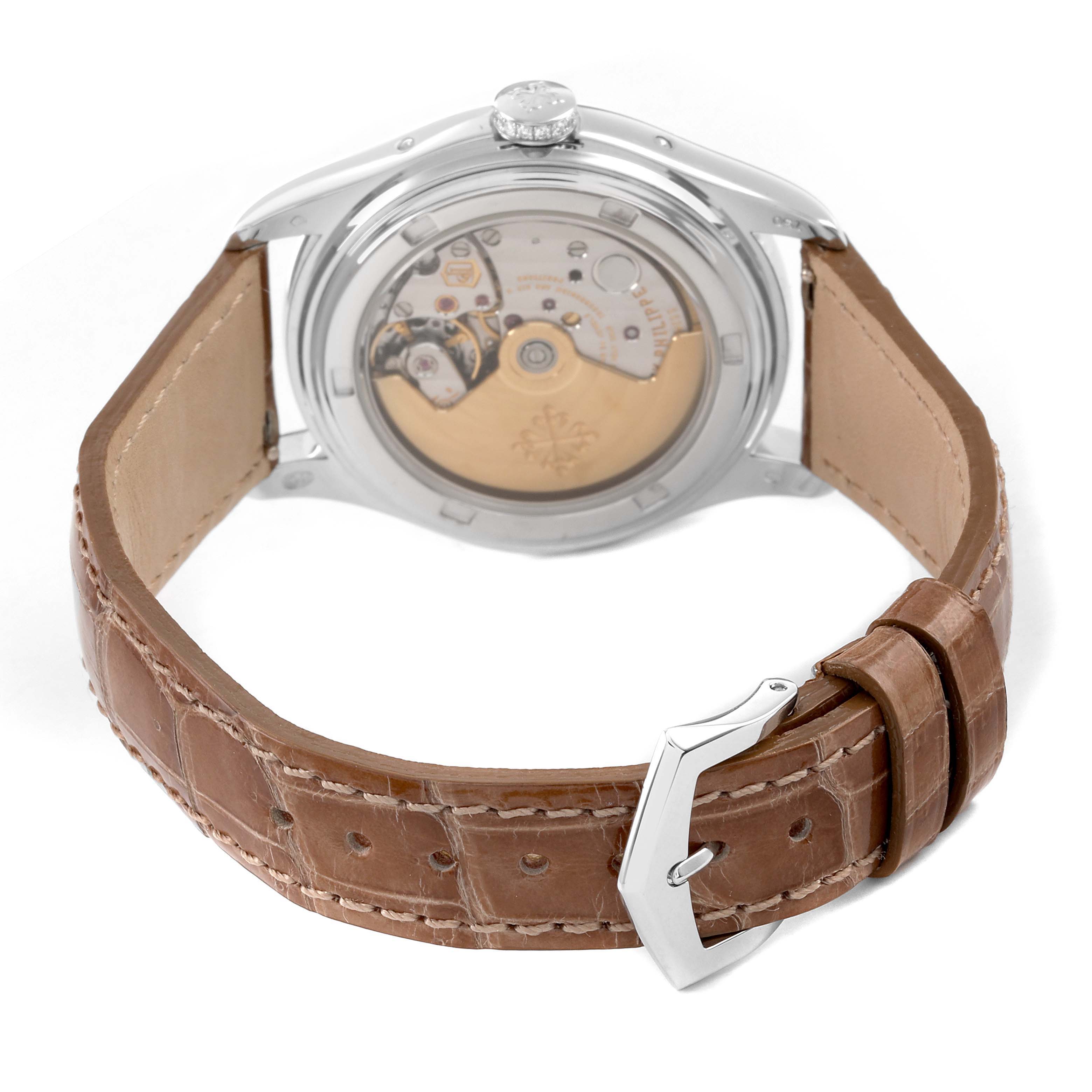 The Patek Philippe Complications 4936 Men's White Gold Mother of Pearl Dial watch is shown from the back, displaying its movement and a brown leather strap with buckle.