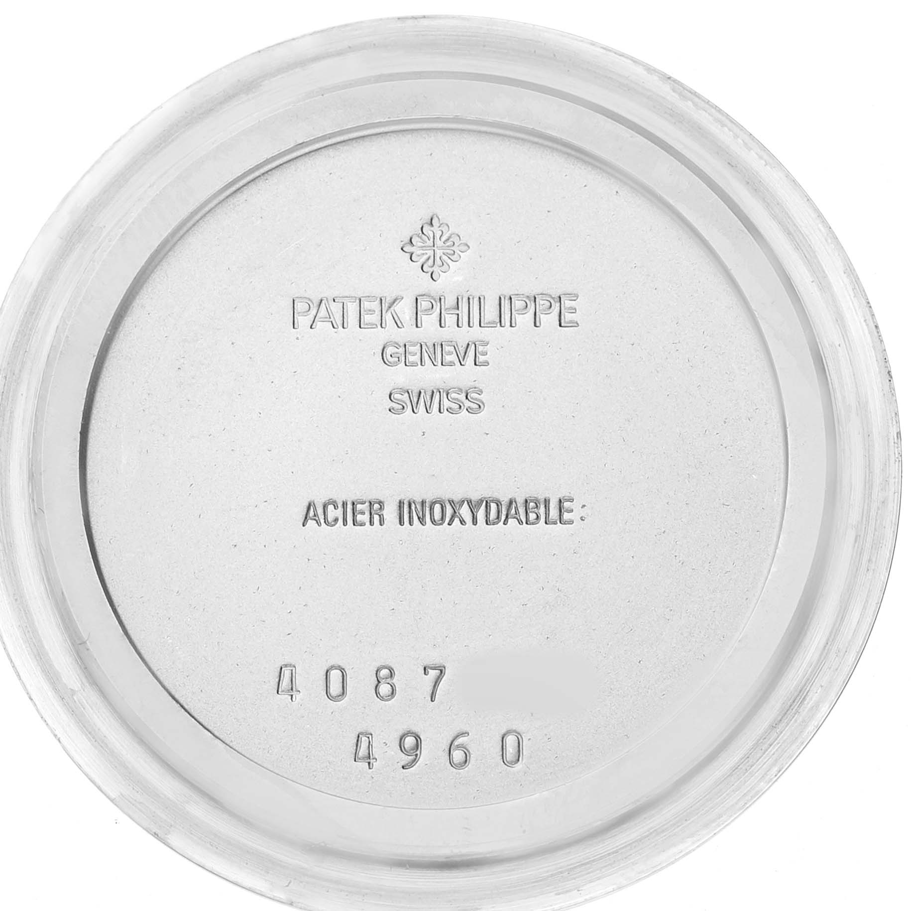 The image shows the inside case back of a Patek Philippe Aquanaut 4960/1A-001 Women's Stainless Steel Black Dial watch, displaying engravings with the brand and model details.