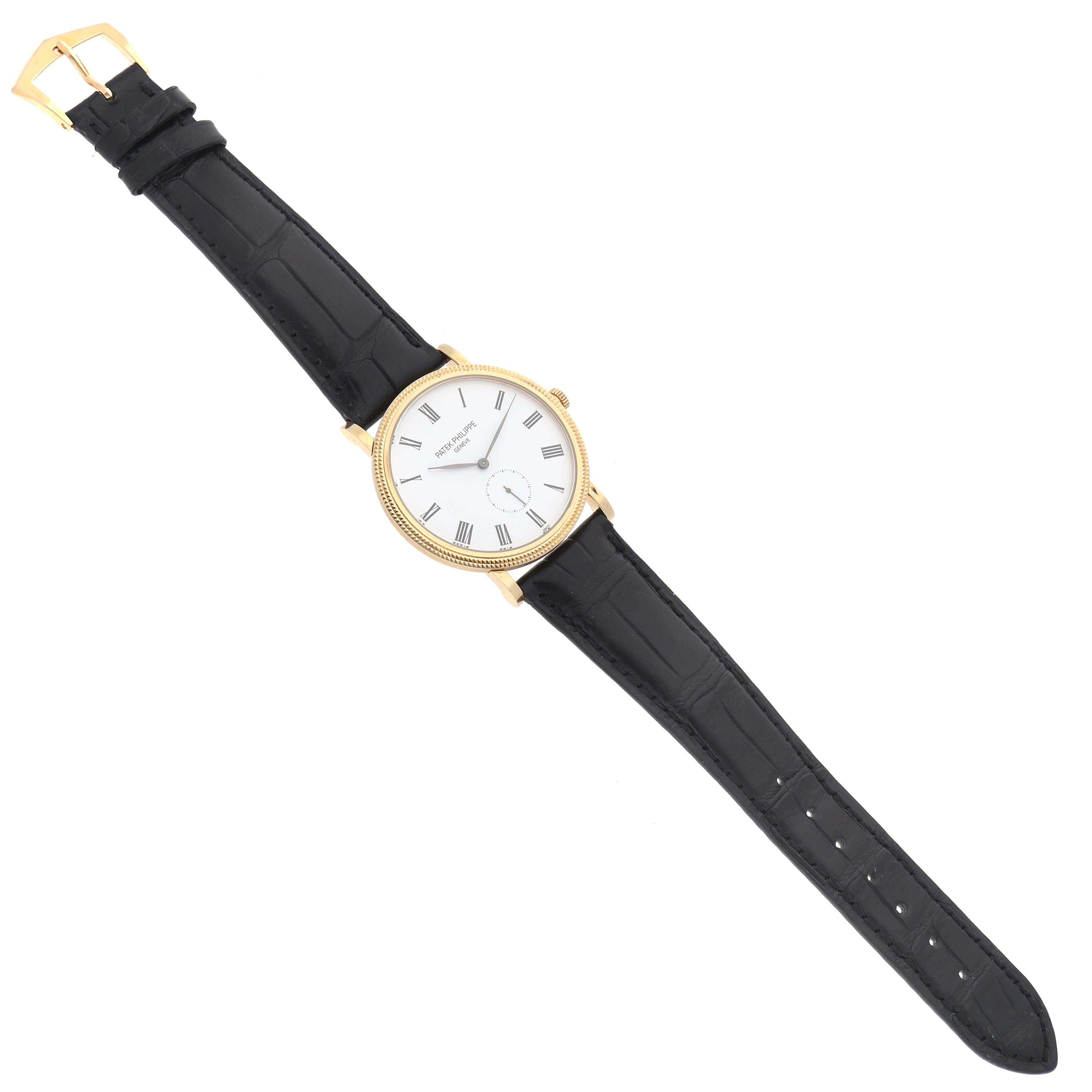 The Patek Philippe Calatrava 5119J Men's Yellow Gold White Dial 5119J Men's Yellow Gold White Dial watch is shown at a slight angle, featuring a round gold case, white dial, Roman numerals, and black leather strap.