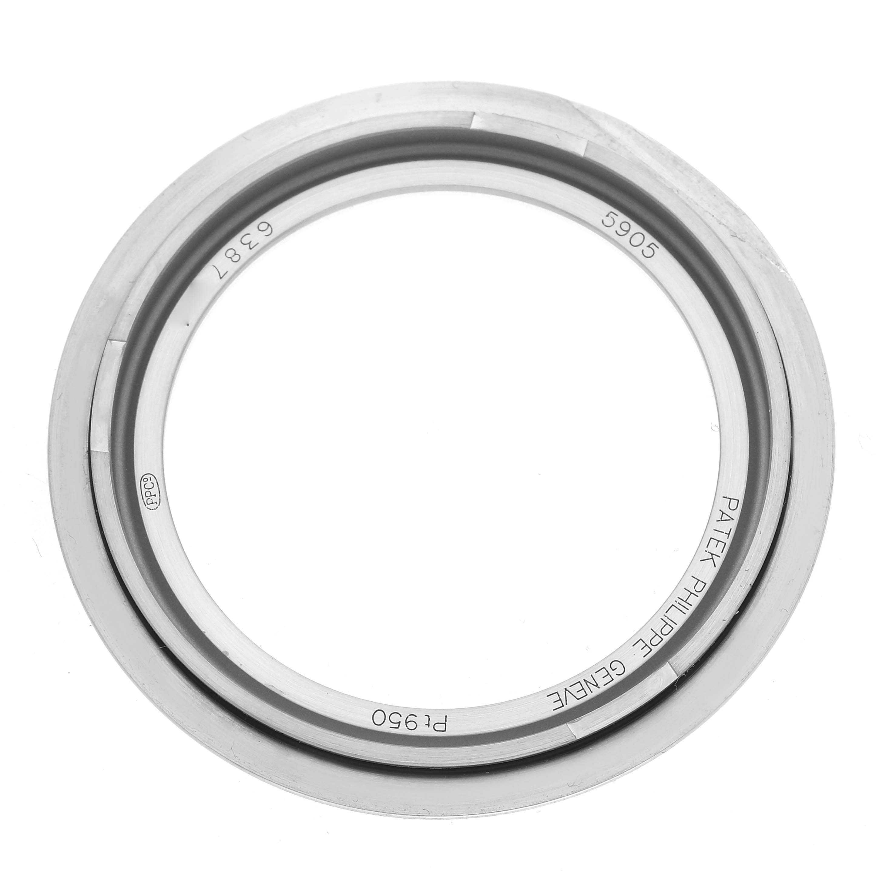 The image shows a bezel of the Patek Philippe Complications 5905P - 001 Men's Platinum Blue Dial 5905P - 001 Men's Platinum Blue Dial model with inscriptions visible from a top-down angle.