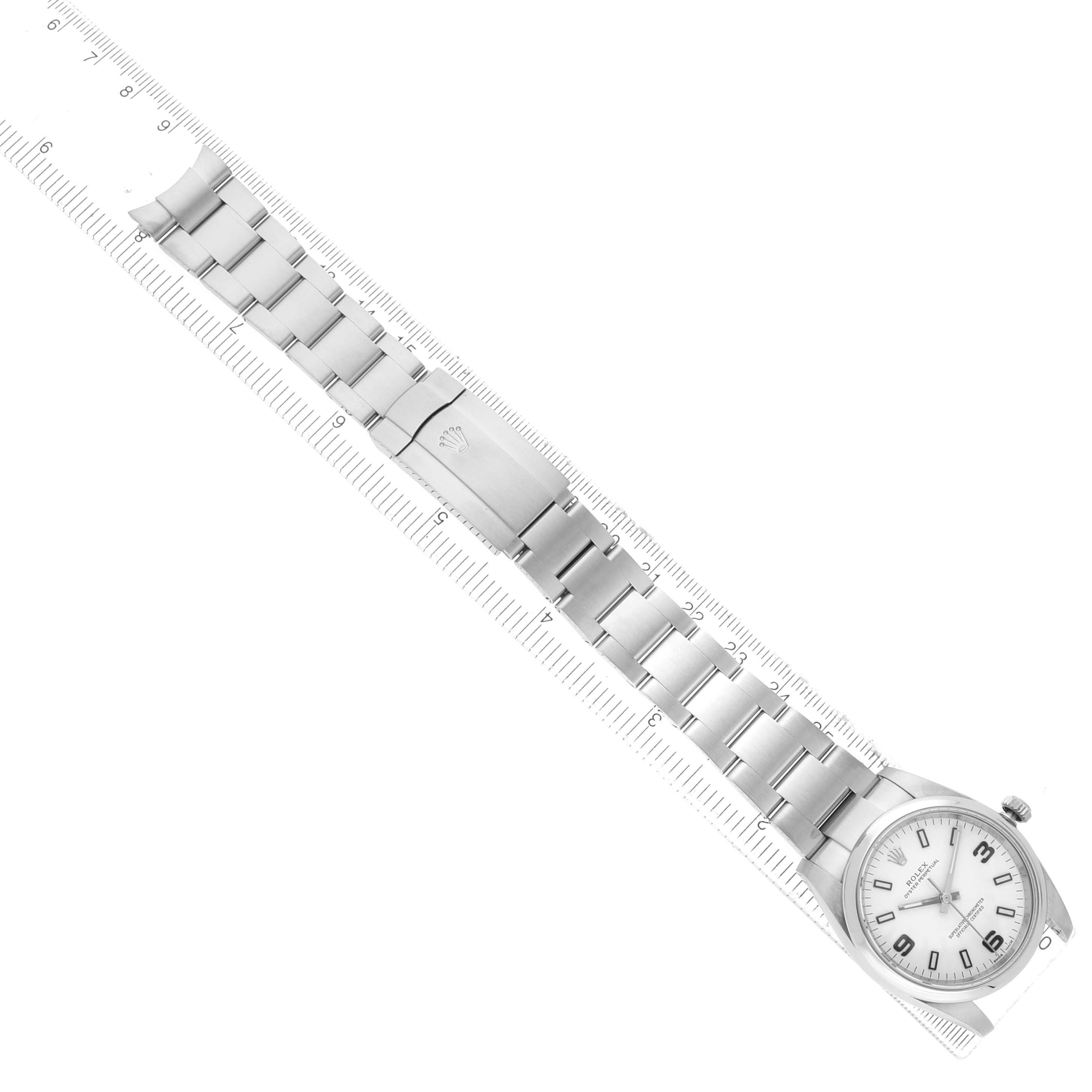 The Rolex Air-King 114200 Men's Stainless Steel White Dial watch is shown from a top-down angle, displaying its face, bezel, bracelet, and clasp.