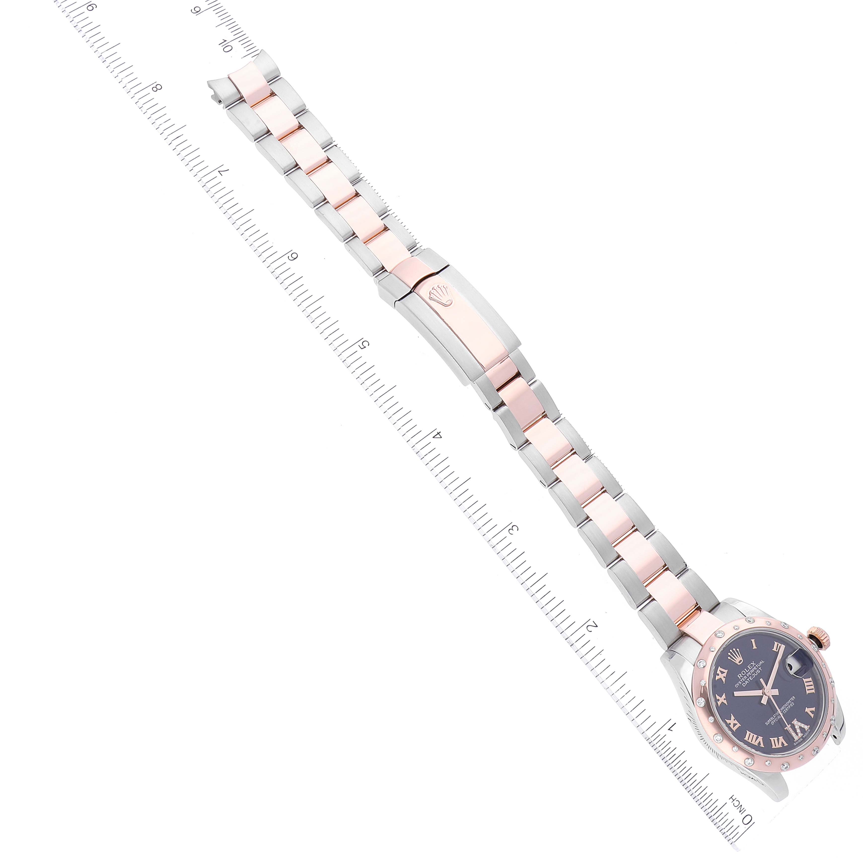 This image shows a Rolex Mid-Size 178341 Women's Steel and Gold (two tone) Purple Dial 178341 Women's Steel and Gold (two tone) Purple Dial watch from an overhead angle, featuring the entire band and dial alongside a ruler for scale.