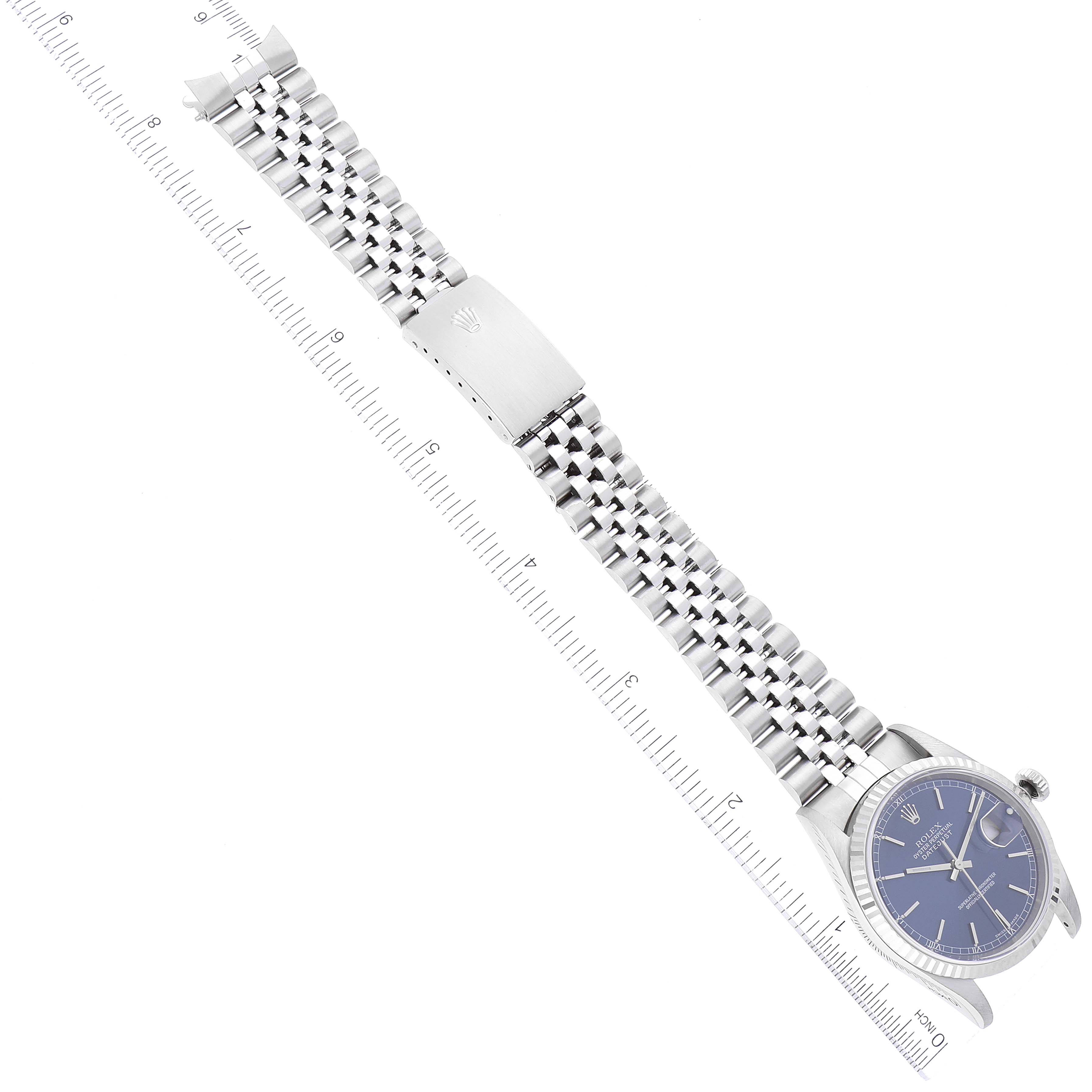 The image shows a Rolex Datejust 16234 Men's Stainless Steel Blue Dial 16234 Men's Stainless Steel Blue Dial watch laid flat with a focus on its bracelet and clasp, alongside a measurement ruler.
