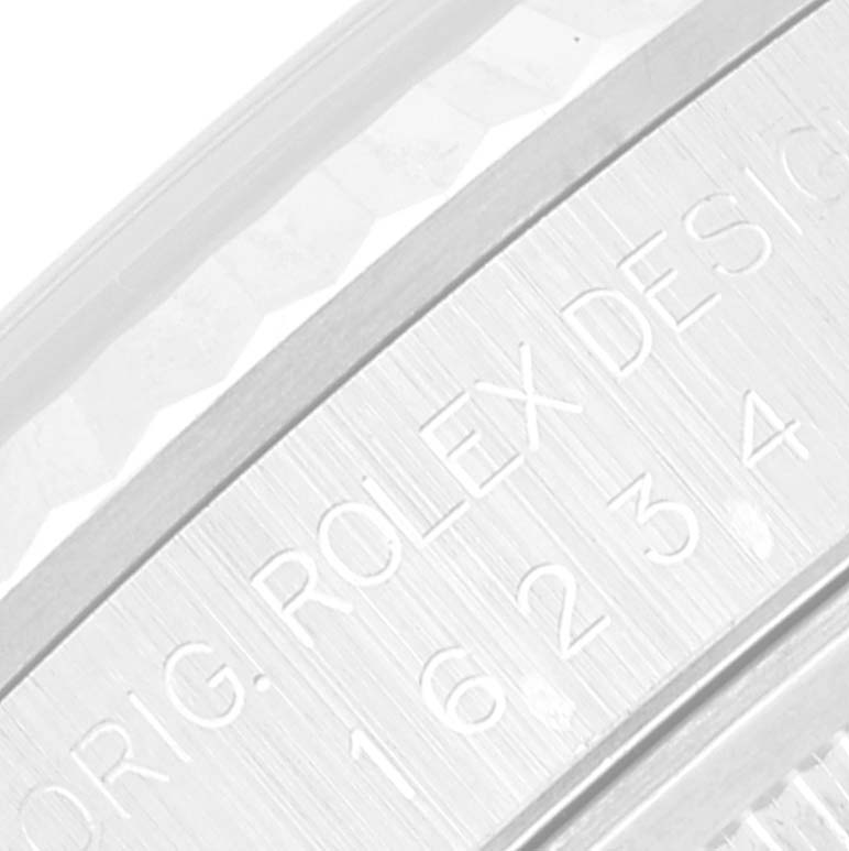 This image shows a close-up of the inner bezel with "ORIG. ROLEX DESIGN 16234" engraved on a Rolex Datejust 16234 Men's Stainless Steel Blue Dial 16234 Men's Stainless Steel Blue Dial watch.