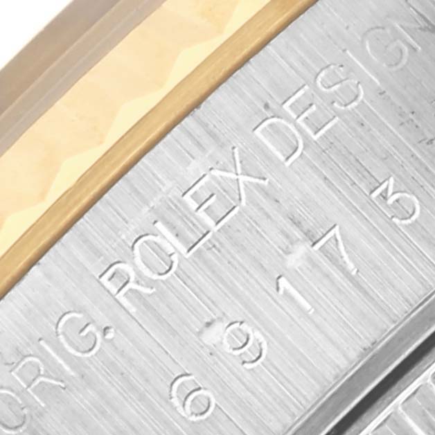 The image shows a close-up of the side of a Rolex Datejust 69173 Women's Steel and Gold (two tone) Blue Dial 69173 Women's Steel and Gold (two tone) Blue Dial watch, highlighting engravings and the edge of the bezel.