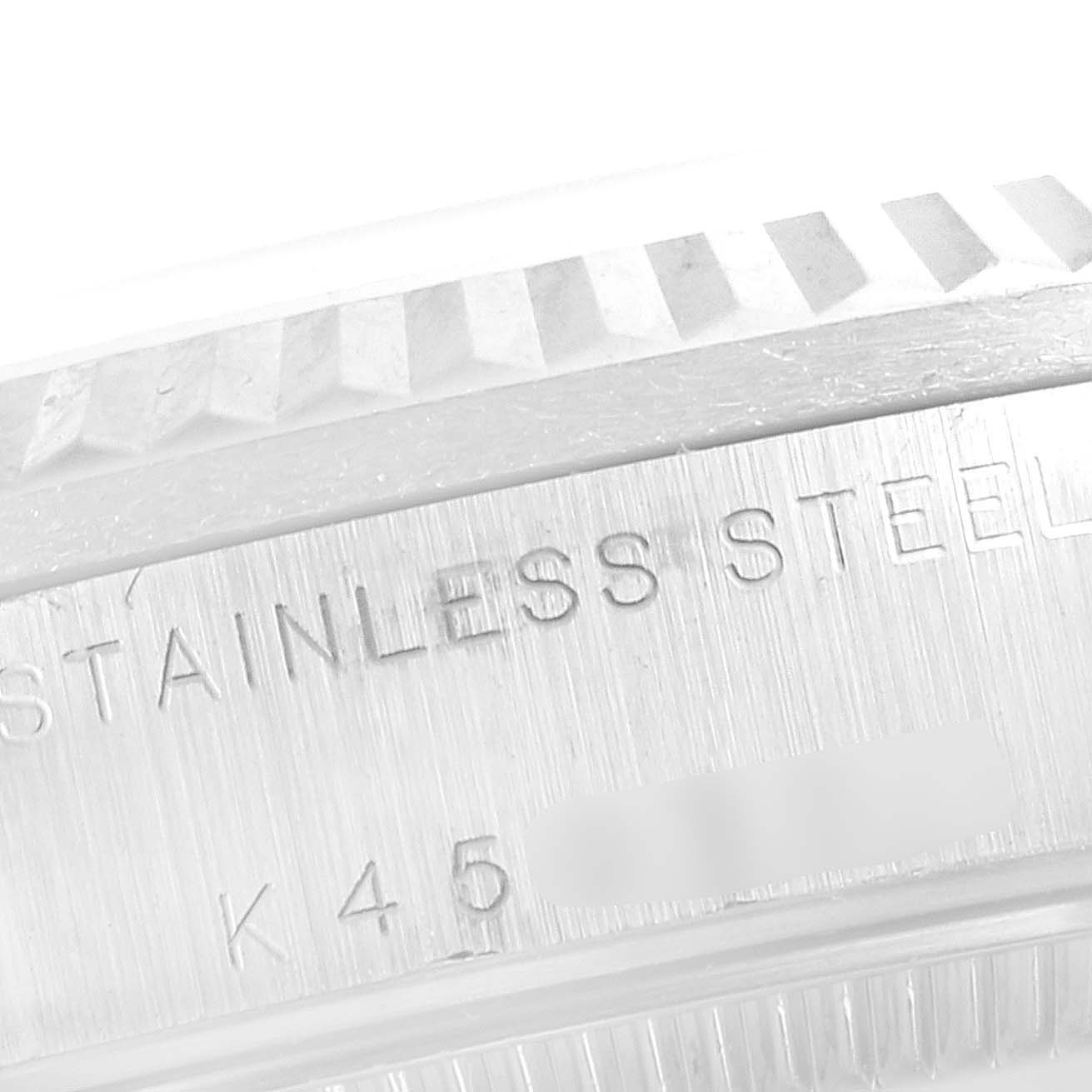 This image shows a close-up of the stainless steel bezel and case back engraving of a Mid-Size Rolex watch.
