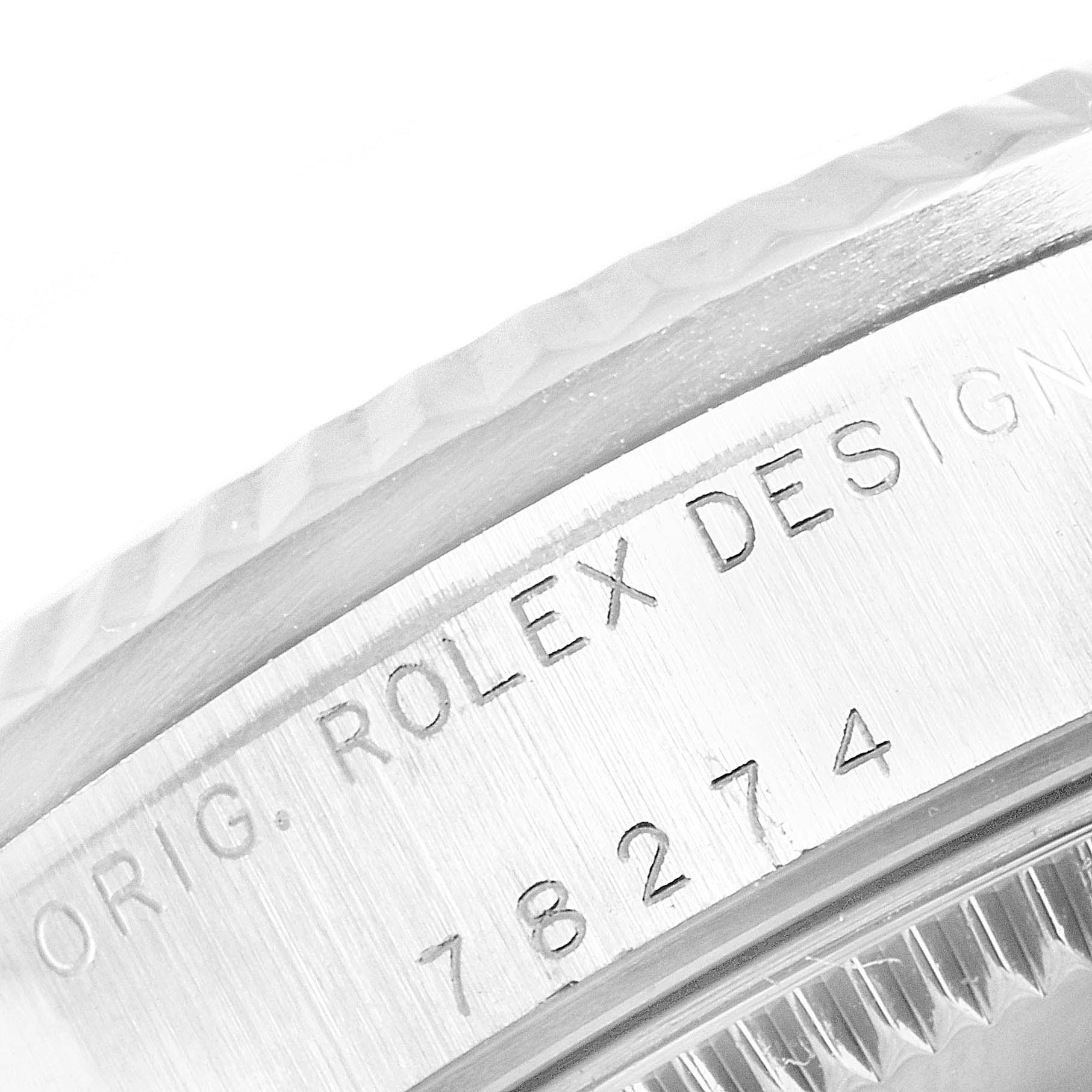 This image shows a macro view of the case side of a mid-size Rolex watch, displaying part of the bezel and "Rolex Design" engraving.