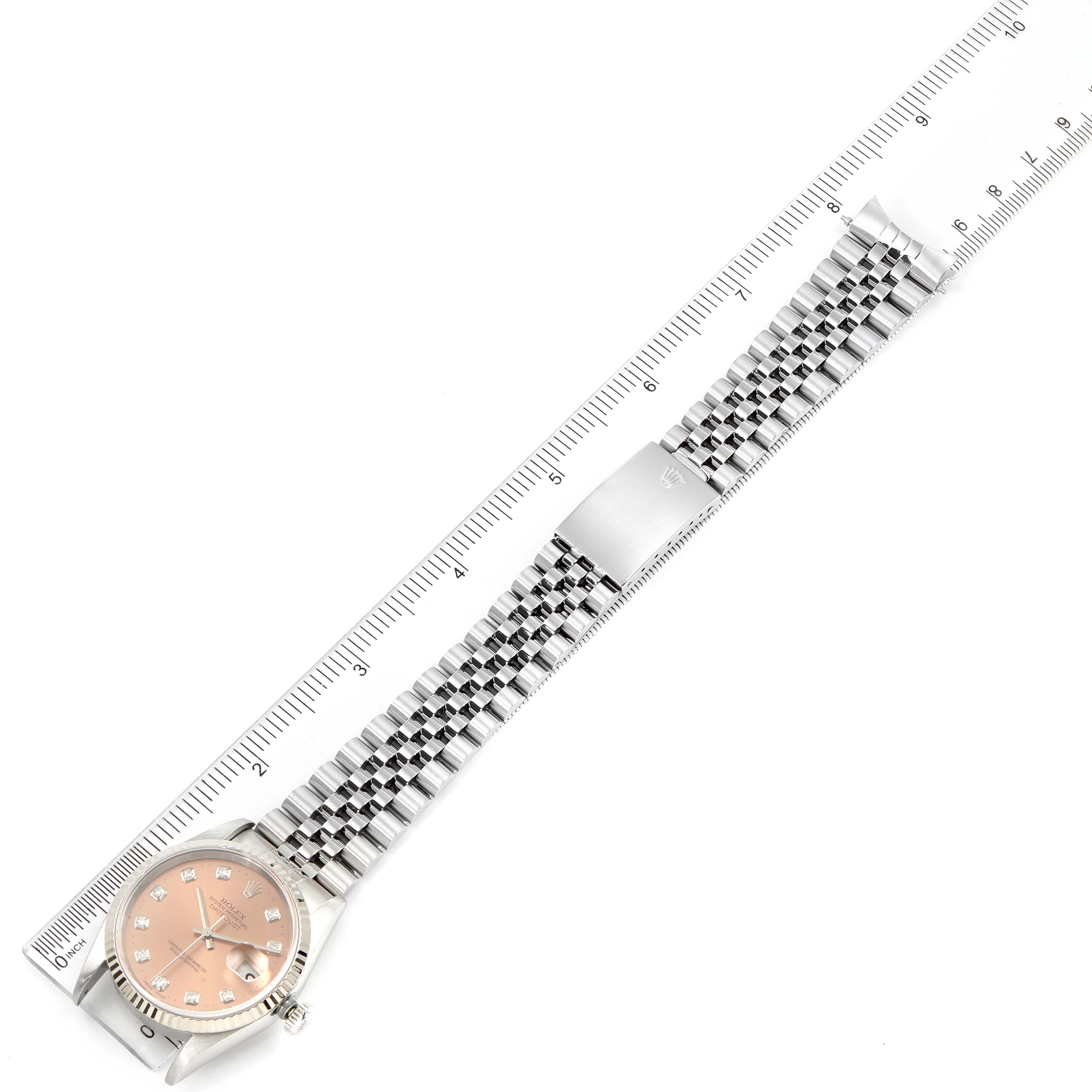 The Rolex Datejust 16234 Men's Stainless Steel Pink Dial 16234 Men's Stainless Steel Pink Dial watch is shown from a top-down angle with its band aligned next to a ruler.