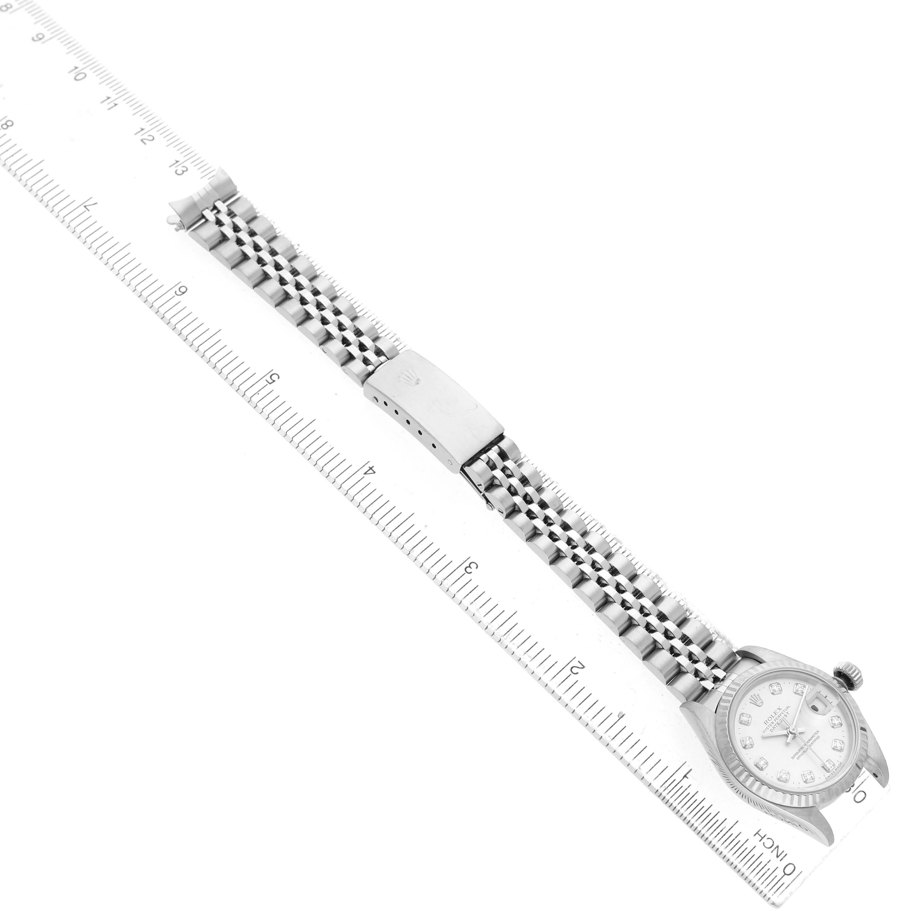 The Rolex Datejust 69174 Women's Stainless Steel Silver Dial watch is shown from a top-down angle, highlighting the dial, bracelet, and clasp, with a ruler for scale.