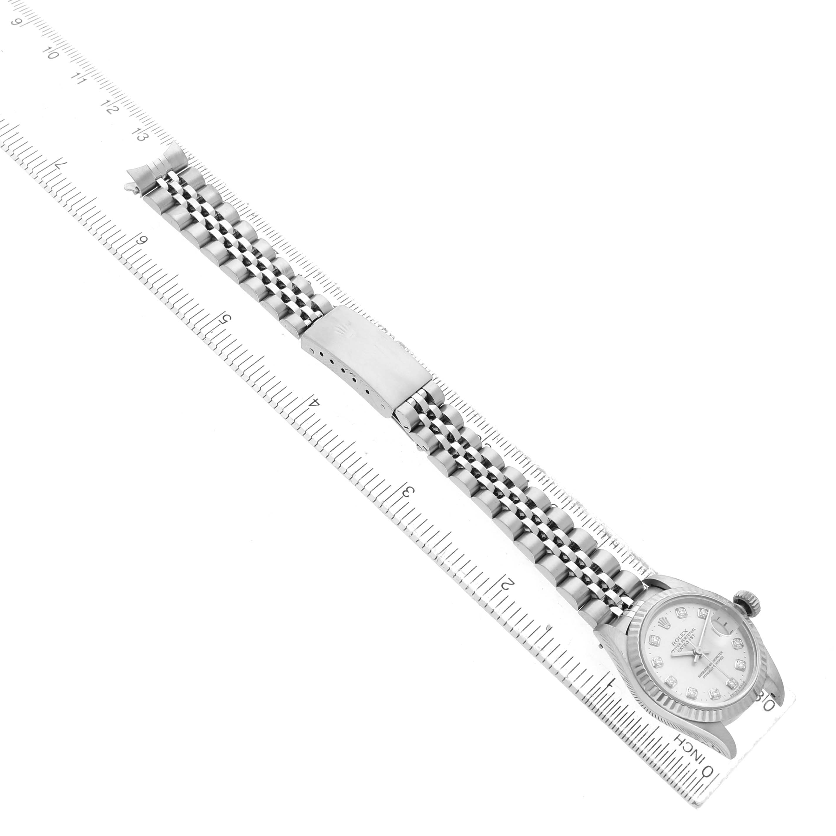 The Rolex Datejust 69174 Women's Stainless Steel Silver Dial watch is shown at an angle, displaying the face and full bracelet next to a ruler for scale.