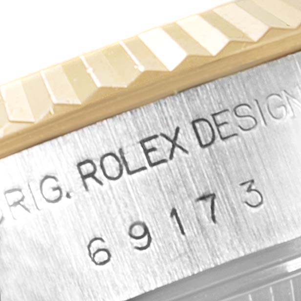 The image shows a close-up of the bezel and the engraved side of a Rolex Datejust 69173 Women
s Steel and Gold (two tone) Grey Dial 69173 Women
s Steel and Gold (two tone) Grey Dial watch.