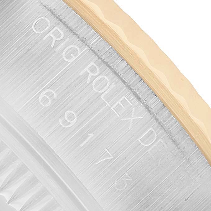 The image shows a close-up side view of the bezel and rehaut engraving on the Rolex Datejust 69173 Women's Steel and Gold (two tone) White Dial watch.