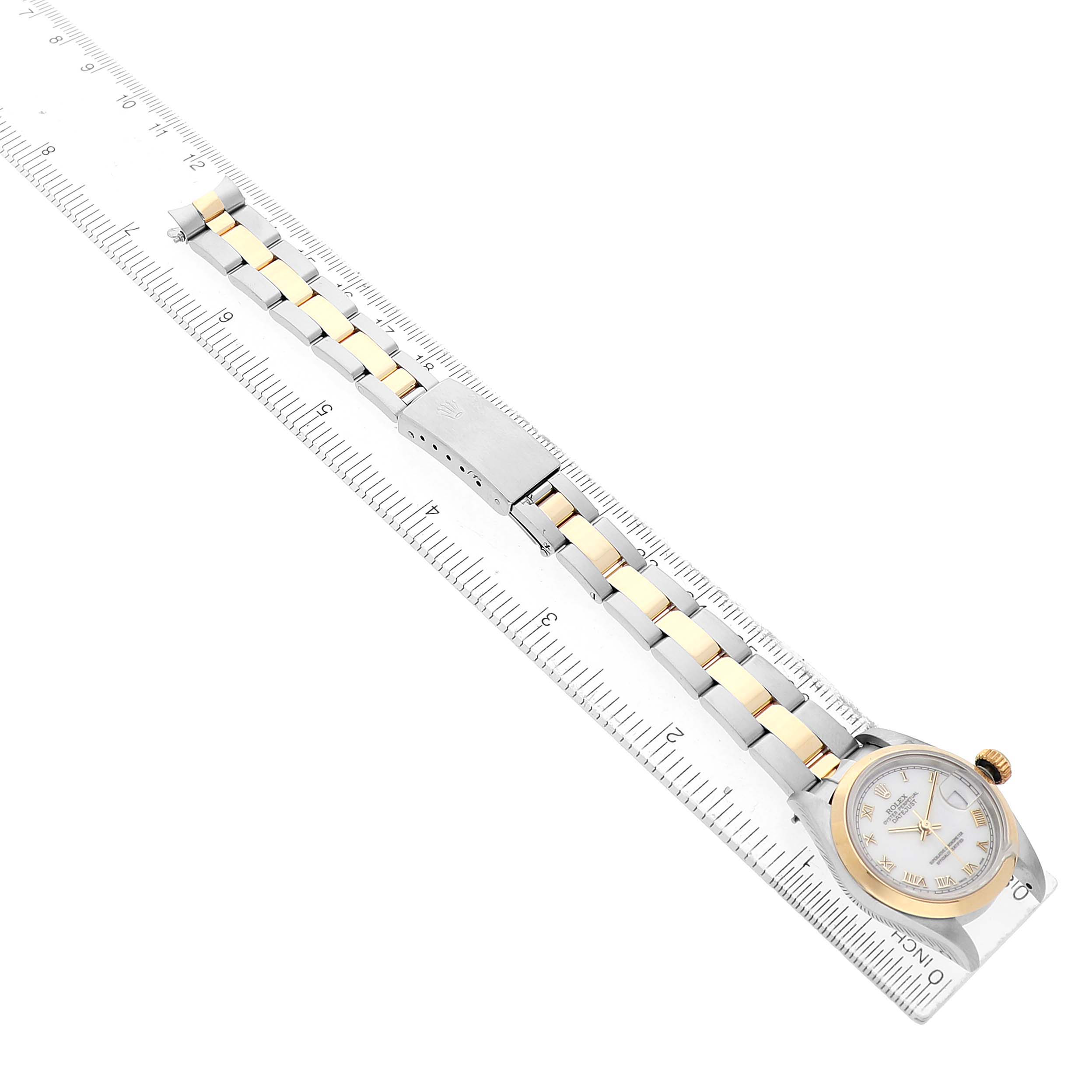 The Rolex Datejust 69163 Women's Steel and Gold (two tone) White Dial watch is shown from a top-down angle, highlighting the face, bezel, and full bracelet on a ruler for measurement.