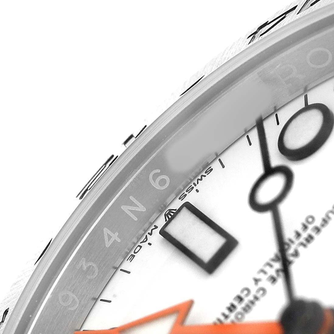 The image shows a close-up angle of the Rolex Explorer 226570 Men's Stainless Steel White Dial, focusing on the dial, orange hand, and bezel markings.