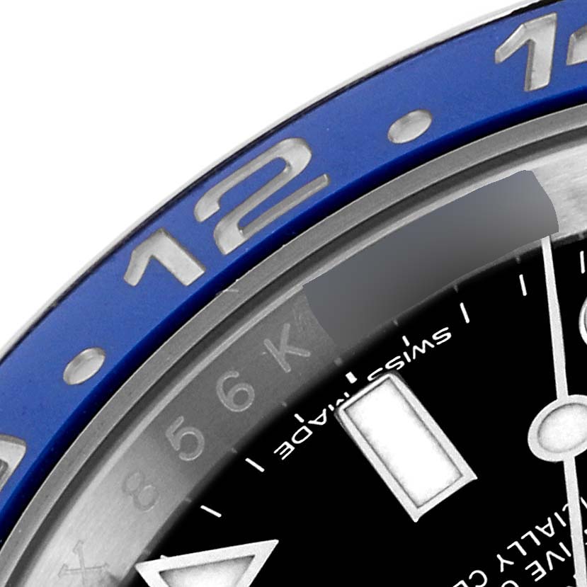 This image shows the bezel and part of the dial of a Rolex GMT-Master 116710 Men's Stainless Steel Black Dial 116710 Men's Stainless Steel Black Dial watch, including the 12 and 6 numerals on the bezel.
