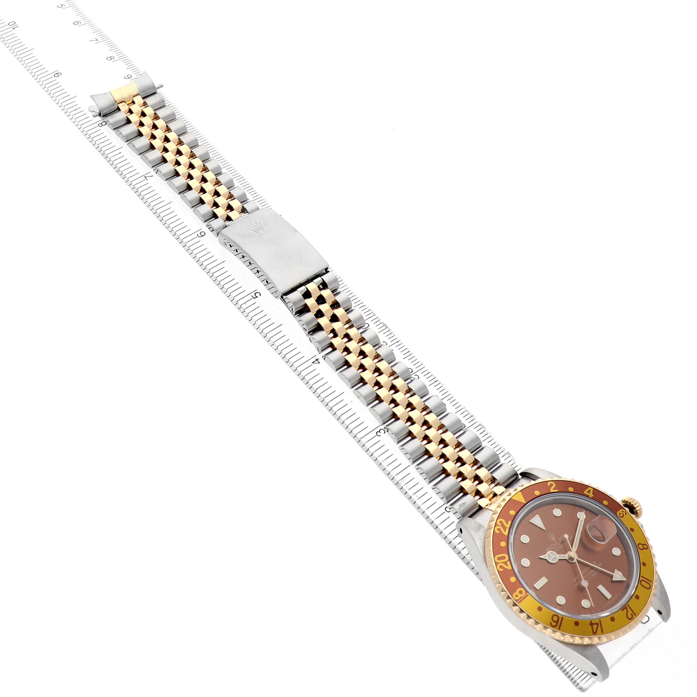 The image shows a Rolex GMT-Master 16713 Men's Steel and Gold (two tone) Brown Dial watch from a top-down angle, highlighting the bezel, dial, and jubilee bracelet.