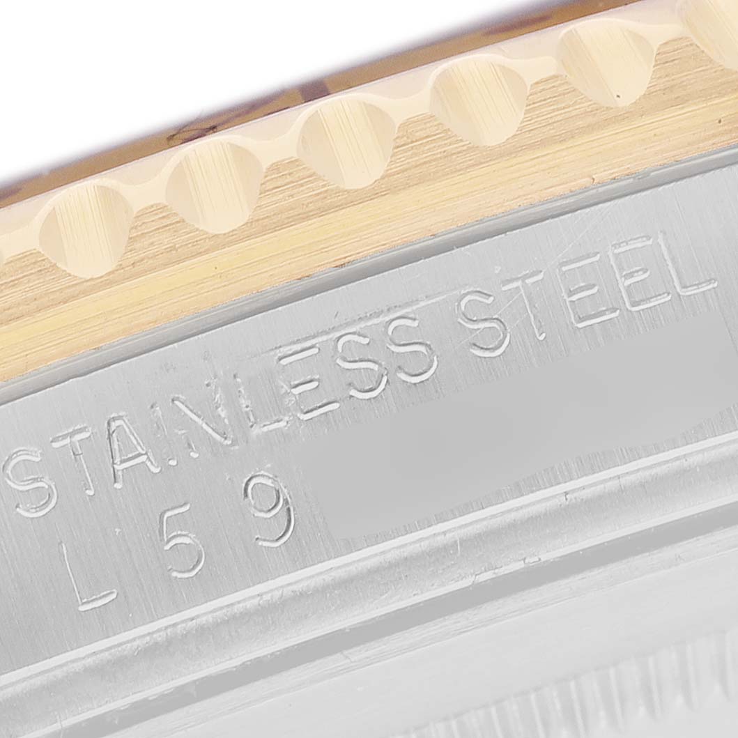 The image shows a close-up of the Rolex GMT-Master 16713 Men's Steel and Gold (two tone) Brown Dial watch, focusing on the stainless steel and bezel area with engraved text.