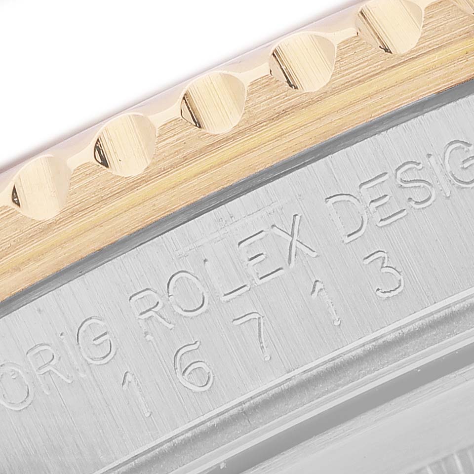 The image shows a close-up angle of the bezel and the engraved side of the Rolex GMT-Master 16713 Men's Steel and Gold (two tone) Brown Dial watch case.