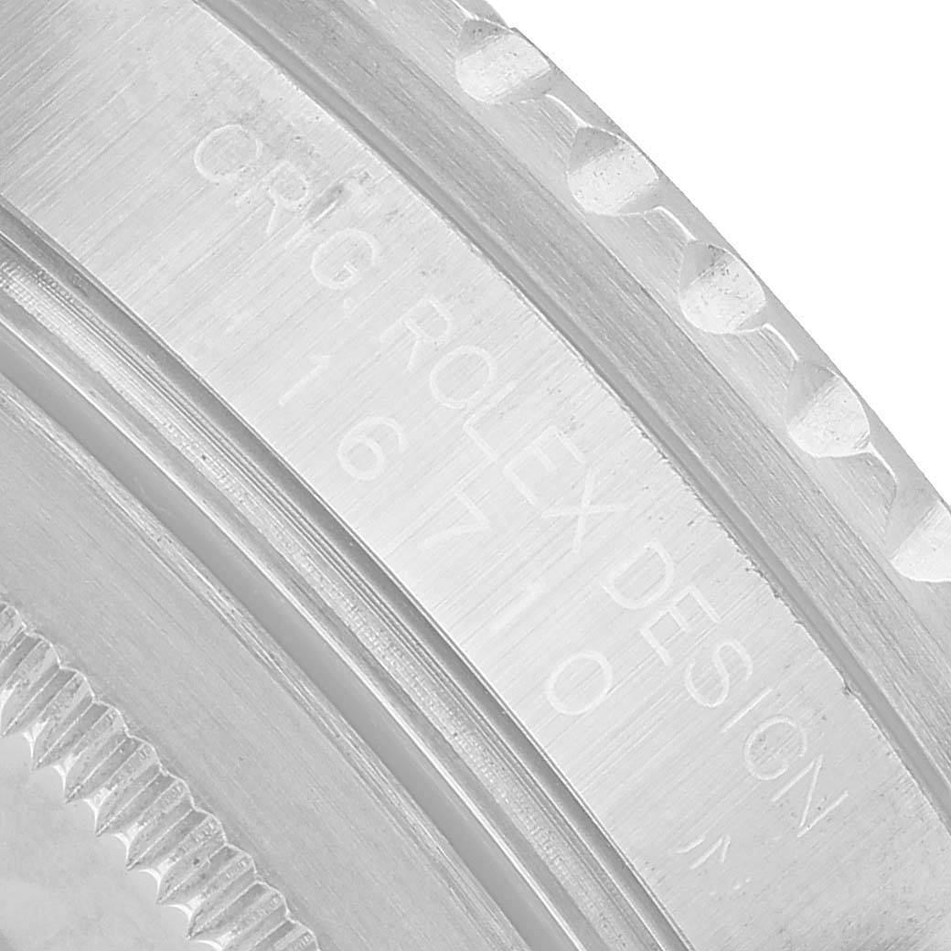 The image shows a close-up of the bezel edge and engraved text on a Rolex GMT-Master 16710 Men's Stainless Steel Black Dial watch case.