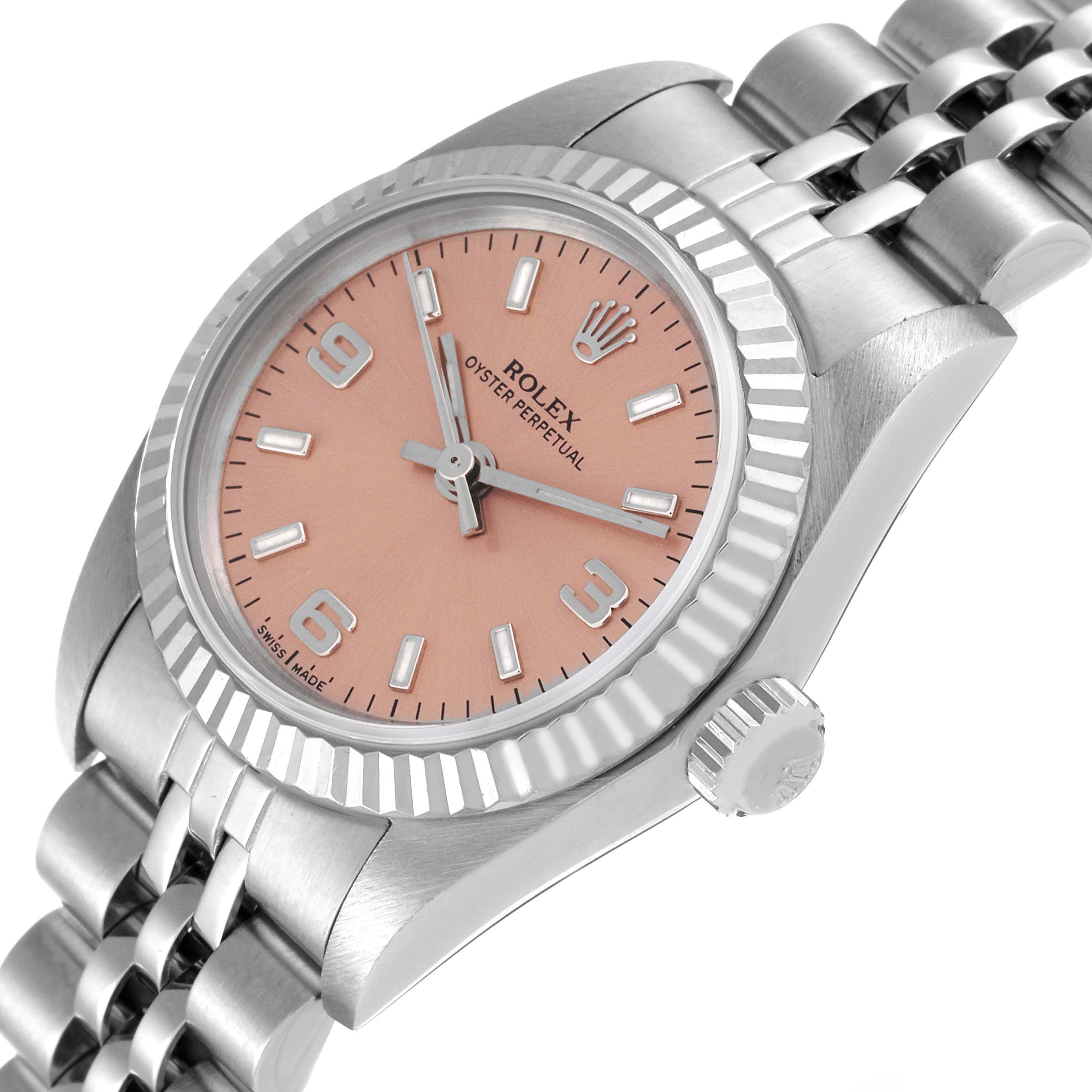 This Rolex Oyster Perpetual 76094 Women
s Stainless Steel Pink Dial 76094 Women
s Stainless Steel Pink Dial watch is shown at an angle displaying the pink dial, fluted bezel, and part of the bracelet.