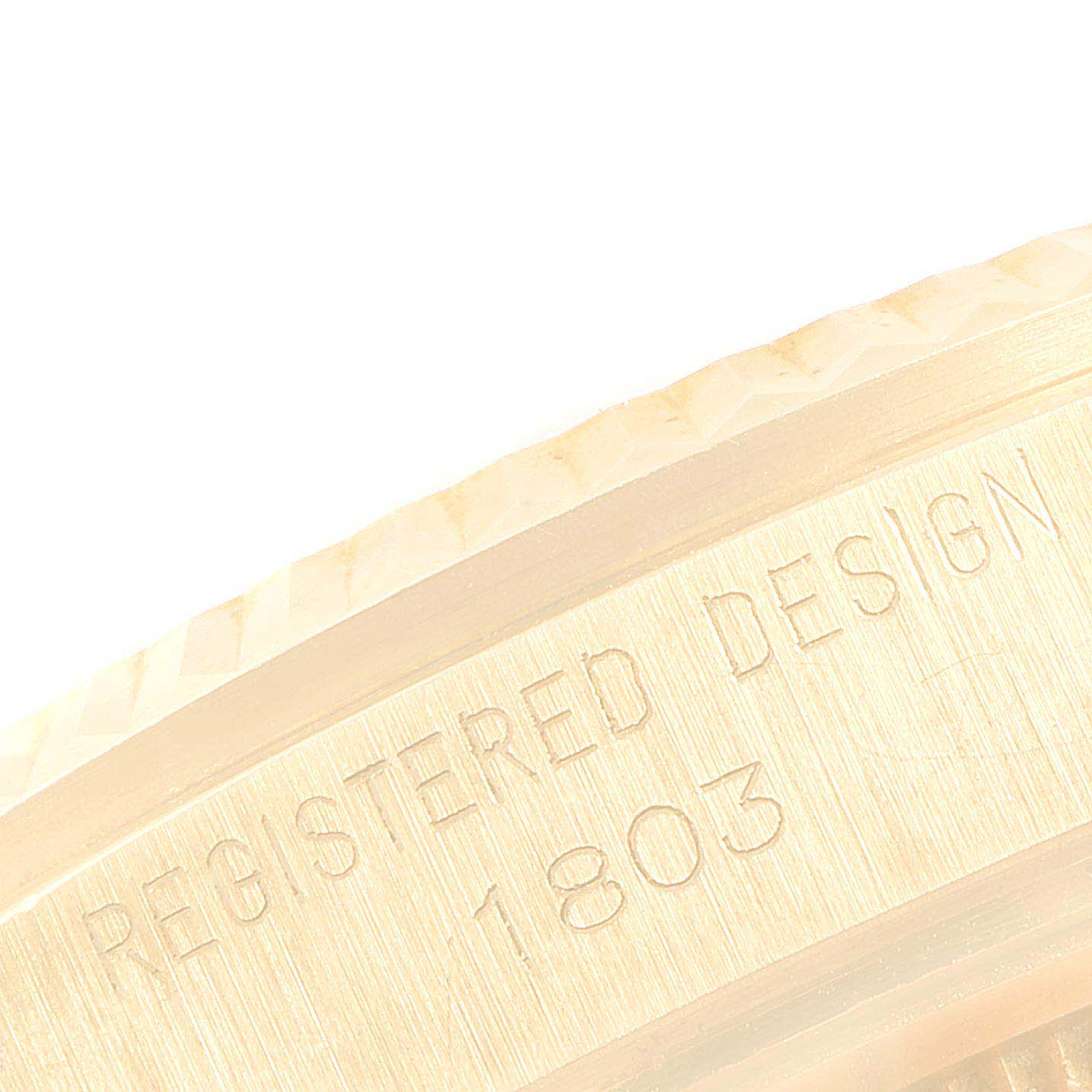 This image shows a close-up of the engraved "REGISTERED DESIGN 1803" on the case of a Rolex Vintage Collection 1803 Men's Yellow Gold Champagne Dial 1803 Men's Yellow Gold Champagne Dial watch.