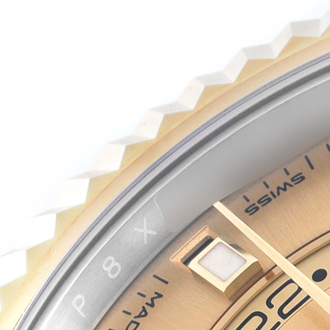 This image shows a close-up of the bezel, a segment of the dial, and an hour marker of the Rolex Sky-Dweller 326933 Men's Yellow Gold Champagne Dial 326933 Men's Yellow Gold Champagne Dial watch.
