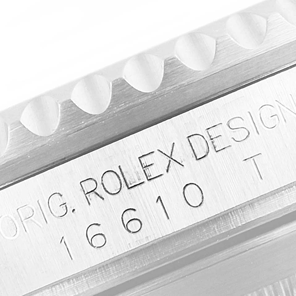The image shows a close-up of the side engraving and bezel edge of a Rolex Submariner 16610 Men
s Stainless Steel Black Dial 16610 Men
s Stainless Steel Black Dial watch.