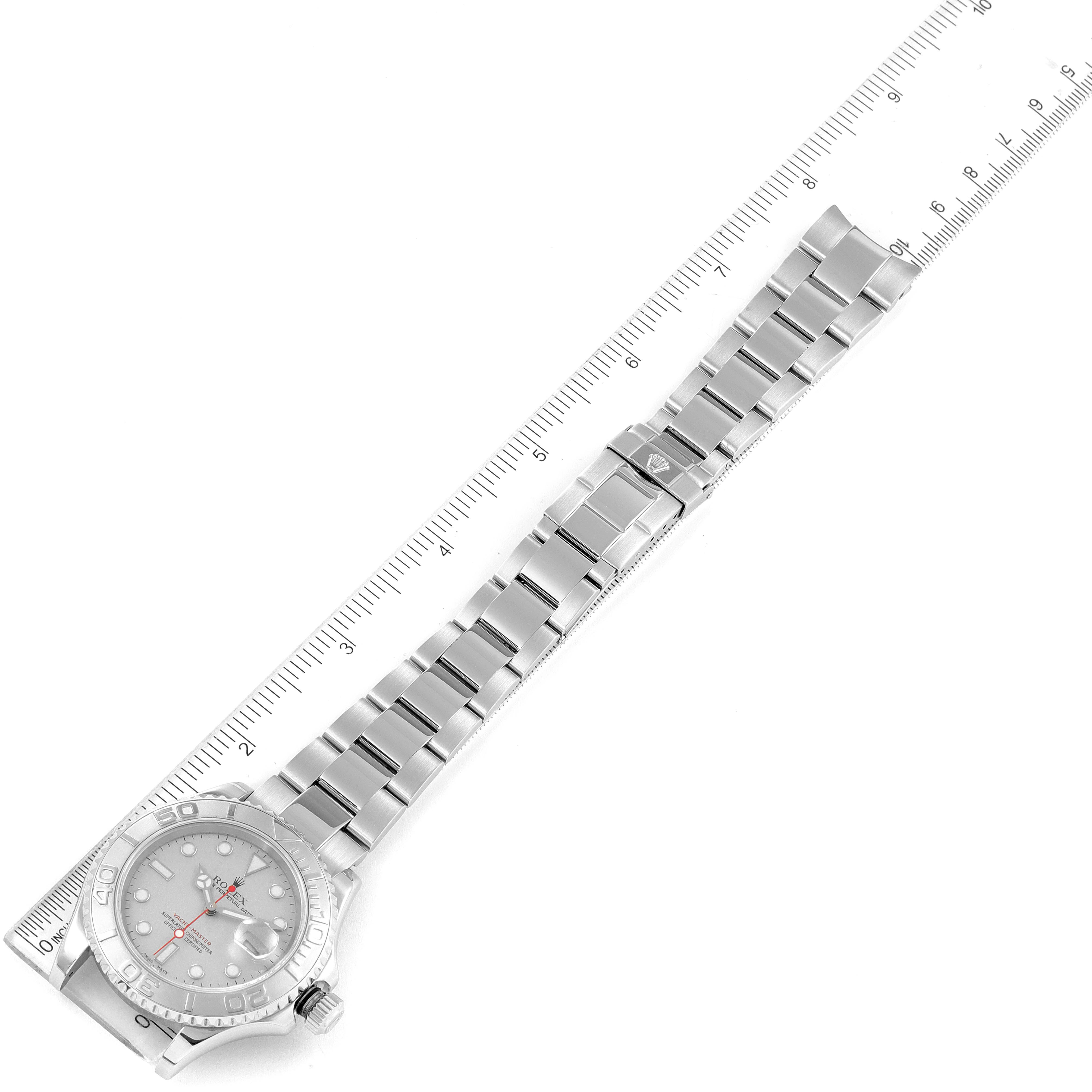 The image shows a top-down view of a Rolex Yacht-Master 16622 Men
s Stainless Steel Silver Dial 16622 Men
s Stainless Steel Silver Dial watch, showcasing its entire bracelet and part of the bezel, alongside a ruler for scale.