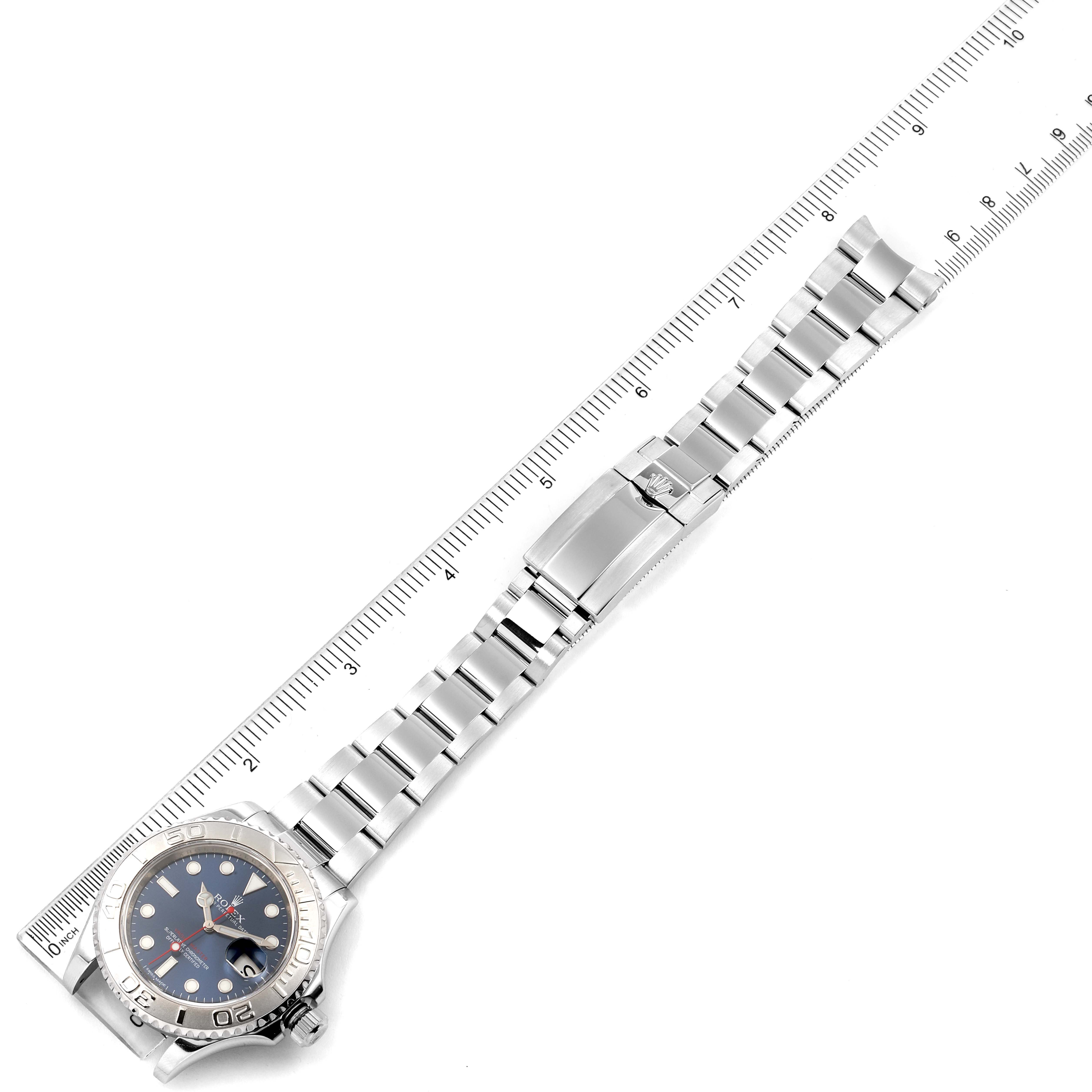 The Rolex Yacht-Master 116622 Men
s Stainless Steel Blue Dial 116622 Men
s Stainless Steel Blue Dial watch is shown in a flat lay angle with the bracelet fully extended alongside a ruler.