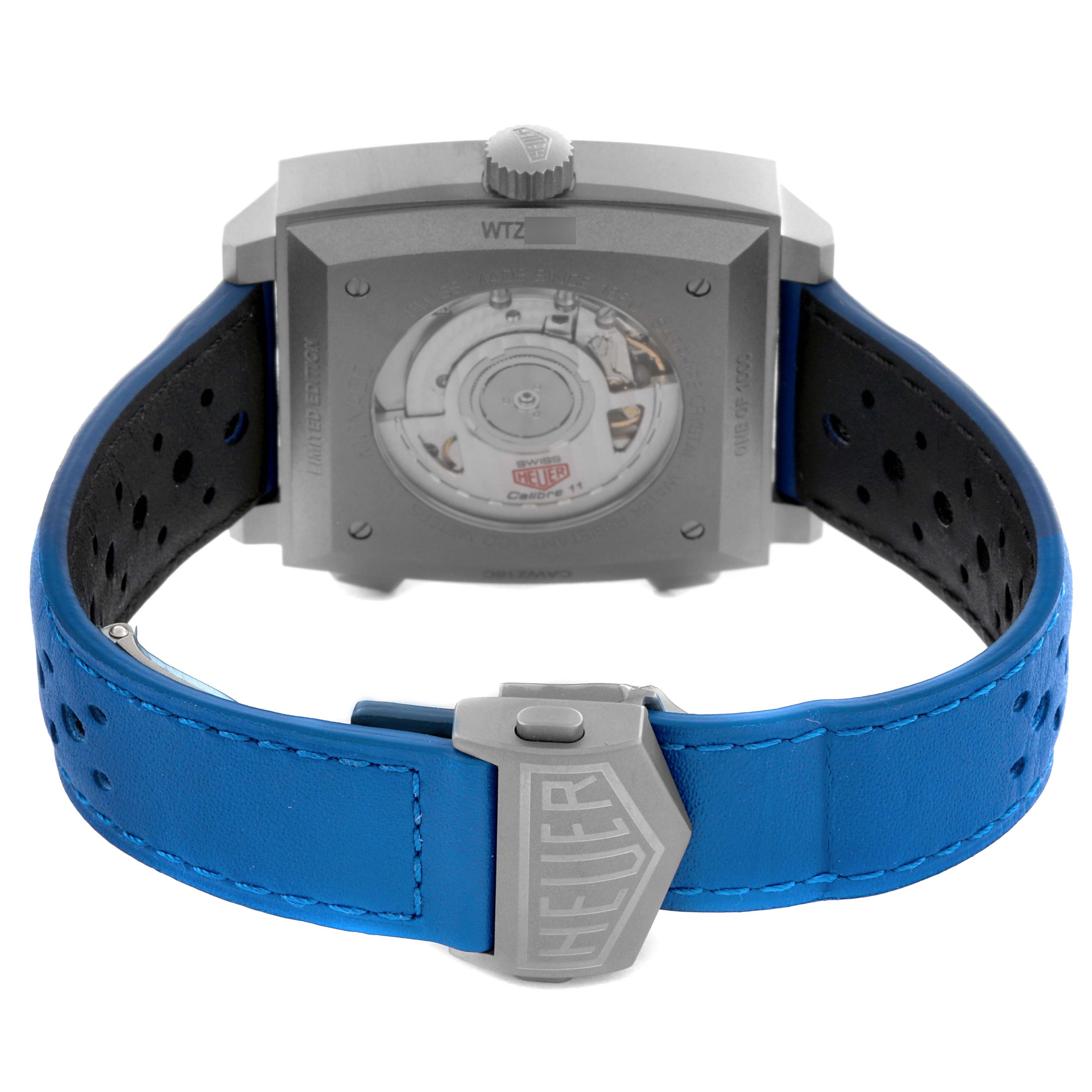 The image shows the back of the Tag Heuer Monaco CAW218C.FC6548 Men's Titanium Silver Dial CAW218C.FC6548 Men's Titanium Silver Dial watch with a view of the automatic movement and a blue perforated strap.