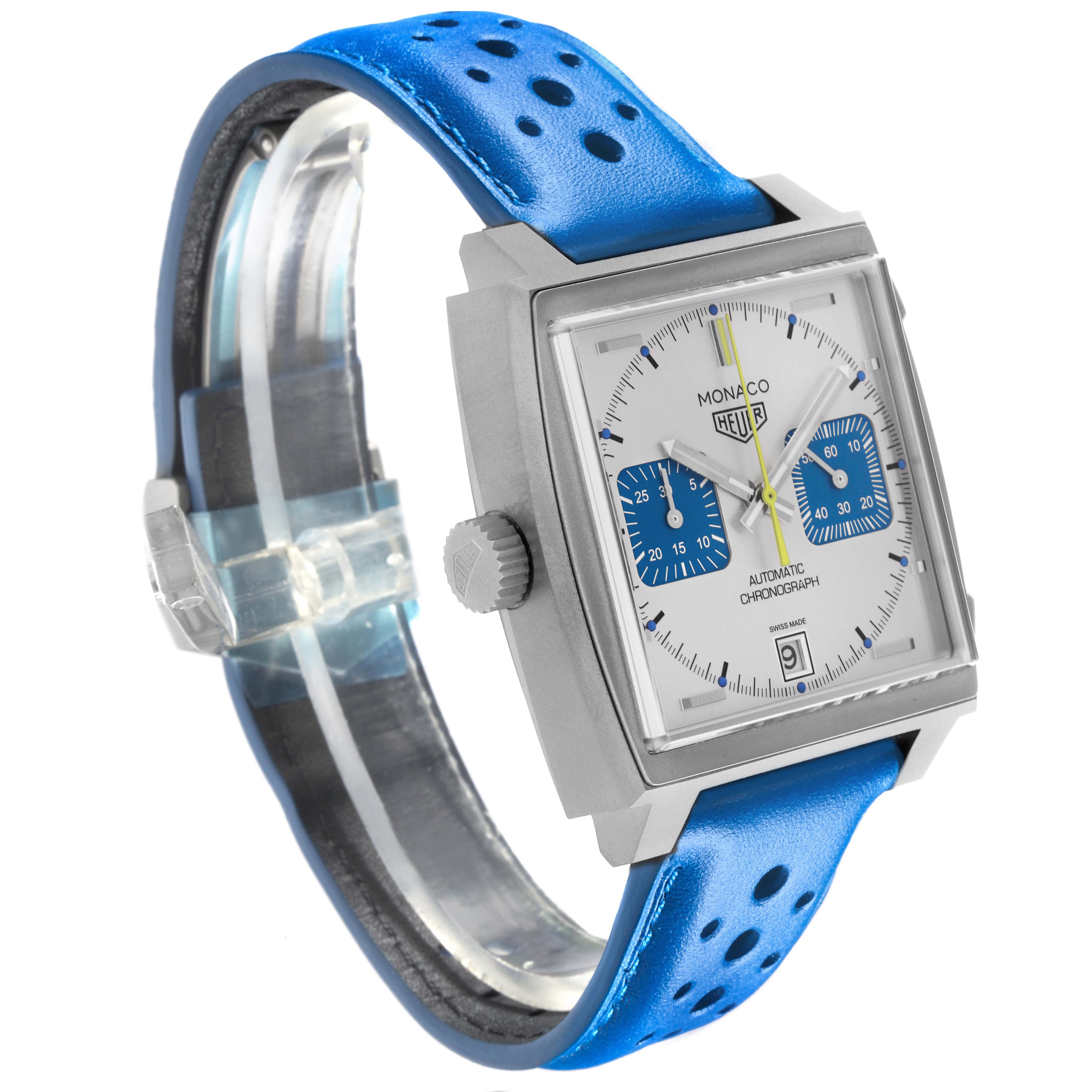 The Tag Heuer Monaco CAW218C.FC6548 Men's Titanium Silver Dial watch is shown at a left-side angle, highlighting its square face, blue dial accents, and blue perforated strap.